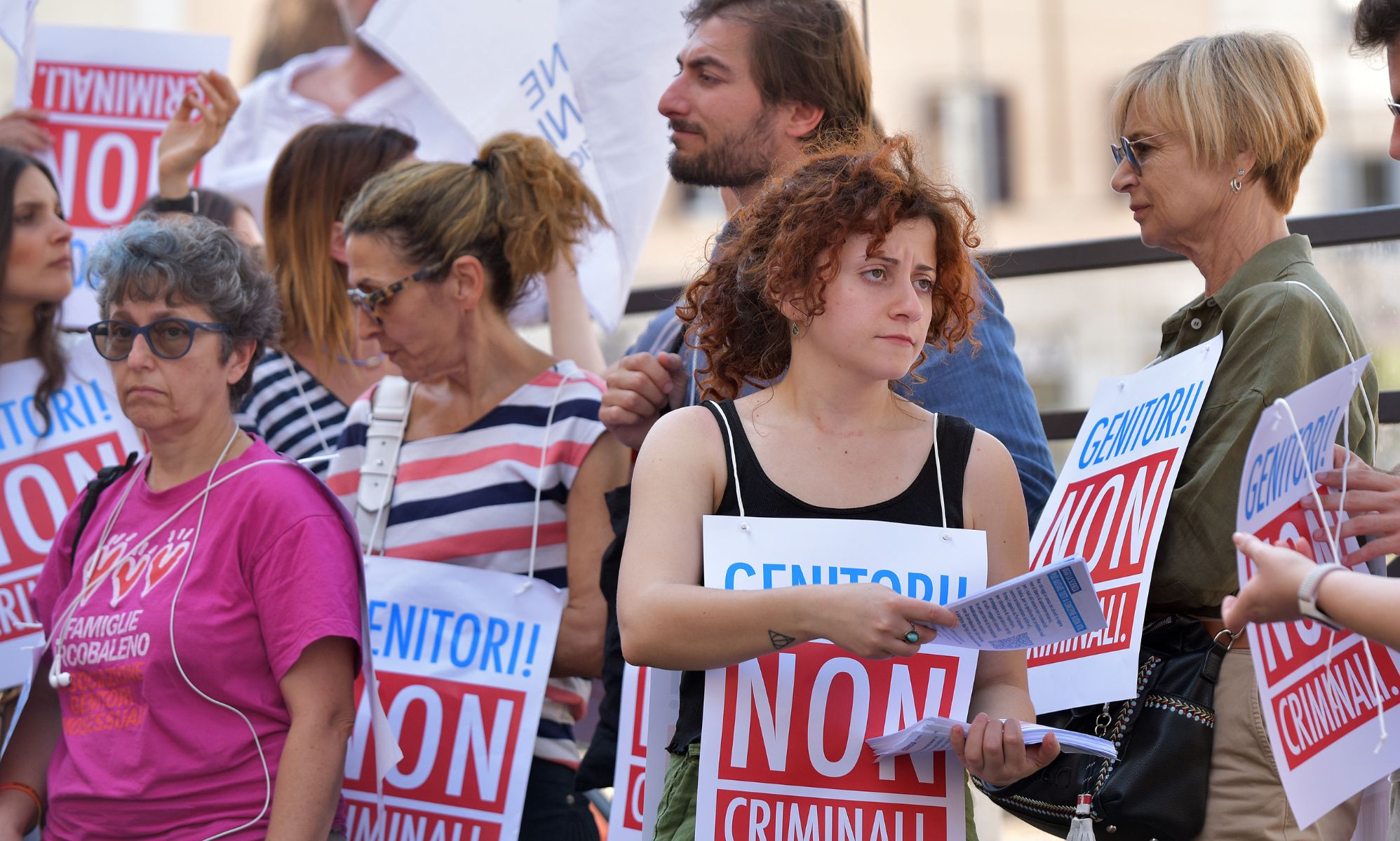 Italian protestors condemning the criminlisation of surrogacy, with signs reading