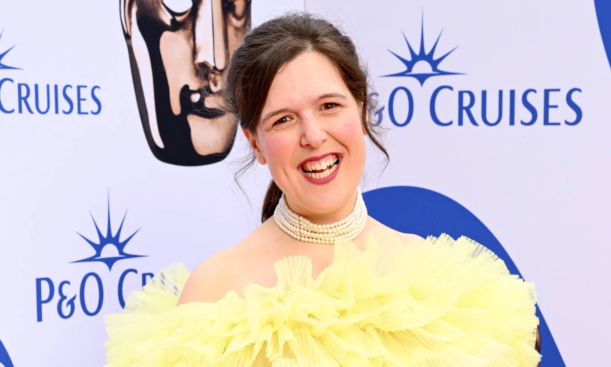 Rosie Jones in a puffy yellow dress at the BAFTA red carpet.