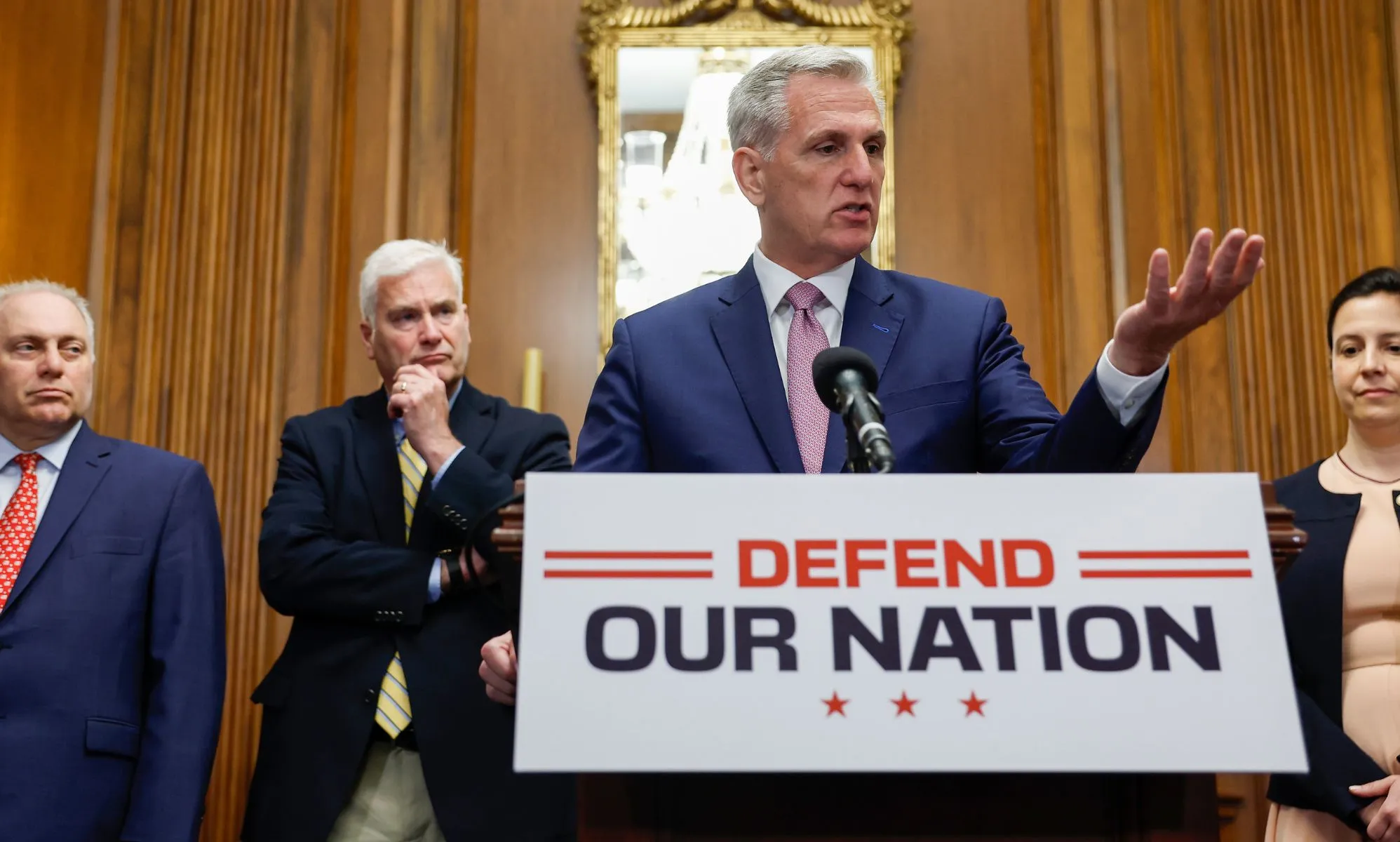 (L-R) Steve Scalise, Tom Emmer, Kevin McCarthy and Elise Stefanik stand around a press room discussing the recently passed National Defense bill, with McCarthy at a podium that says