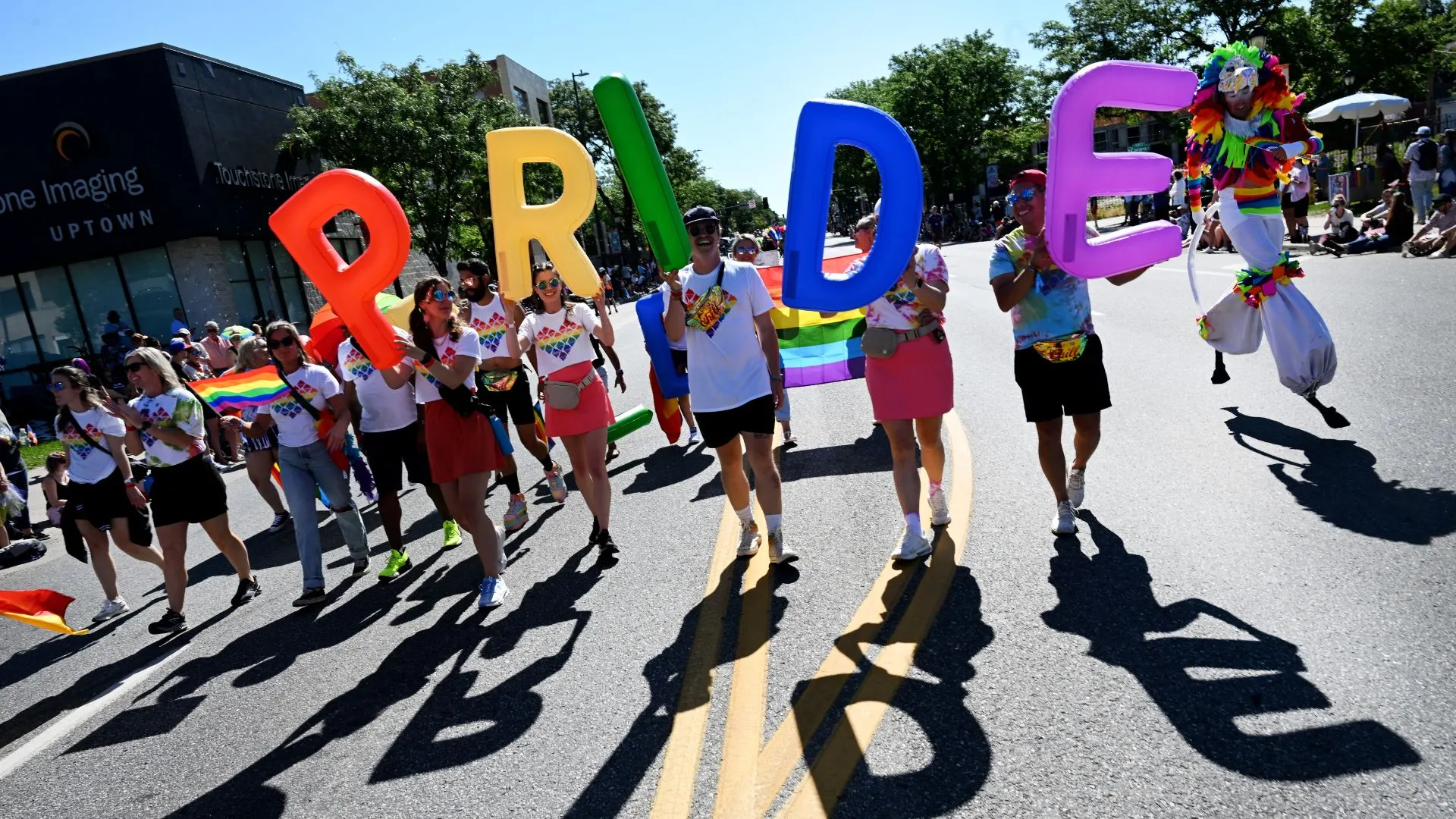 Revellers carry rainbow-coloured balloons that spell out PRIDE at a Pride parade in Denver, Colorado on June 25, 2023