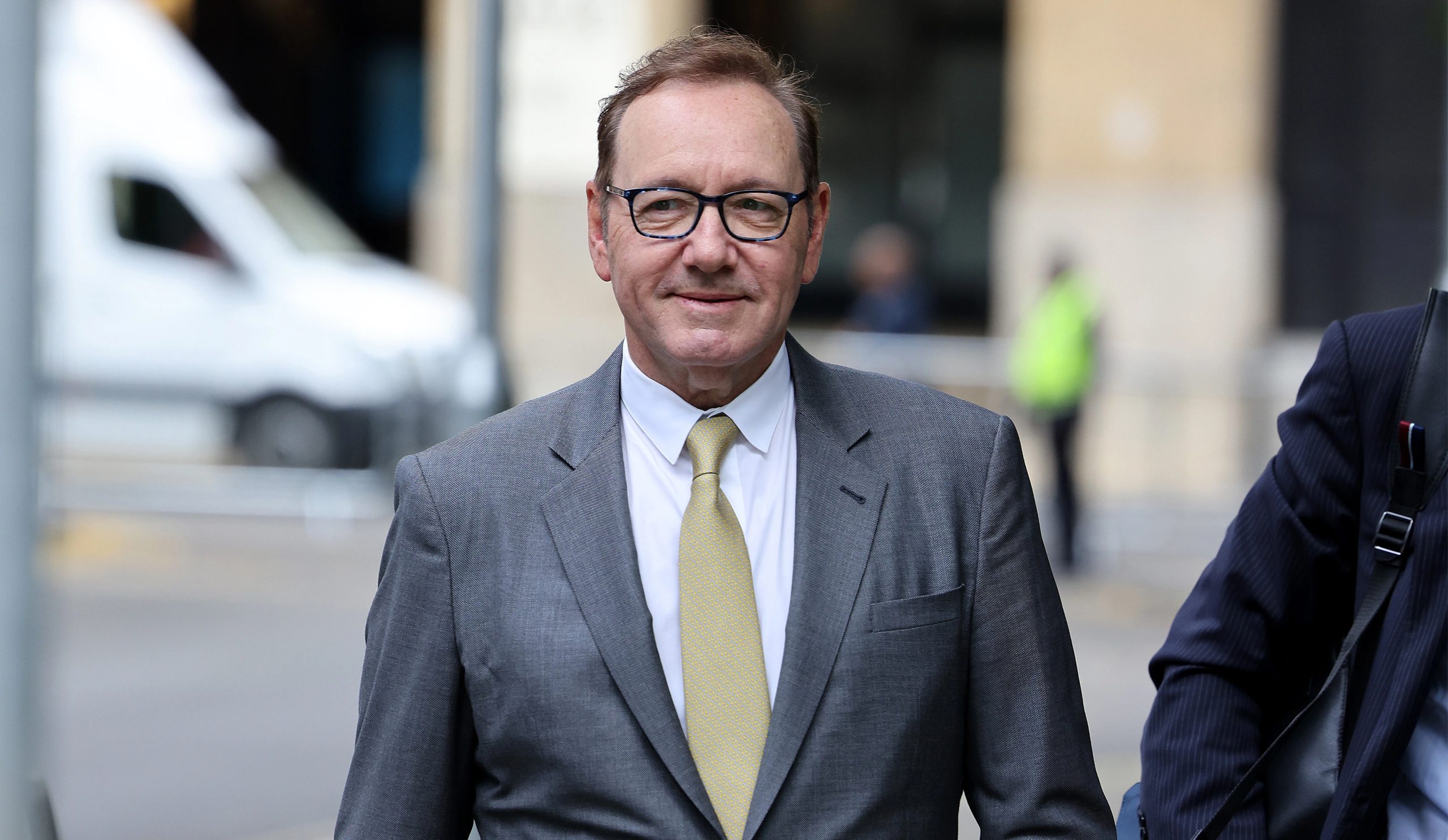 Actor Kevin Spacey arrives at Southwark Crown Court on June 30, 2023 wearing a grey suit and yellow tie