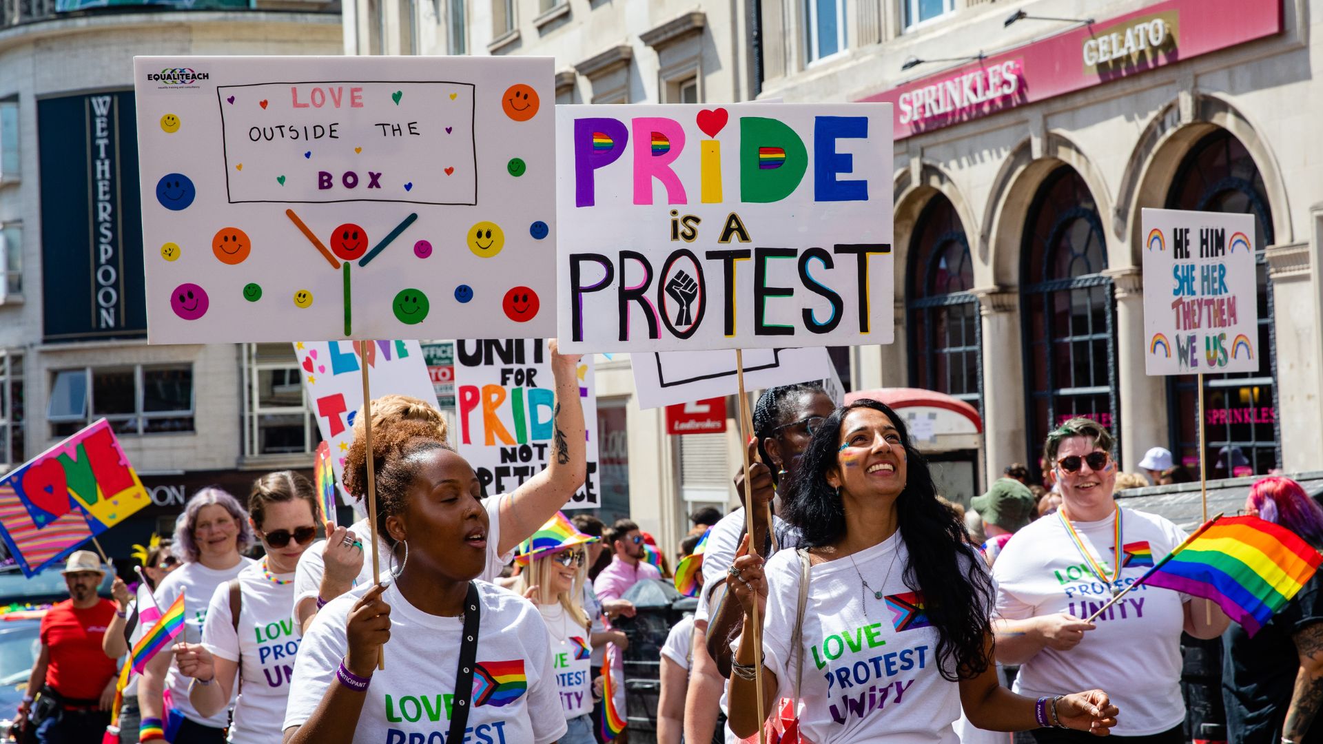 Revellers hold signs at Brighton Pride 2022