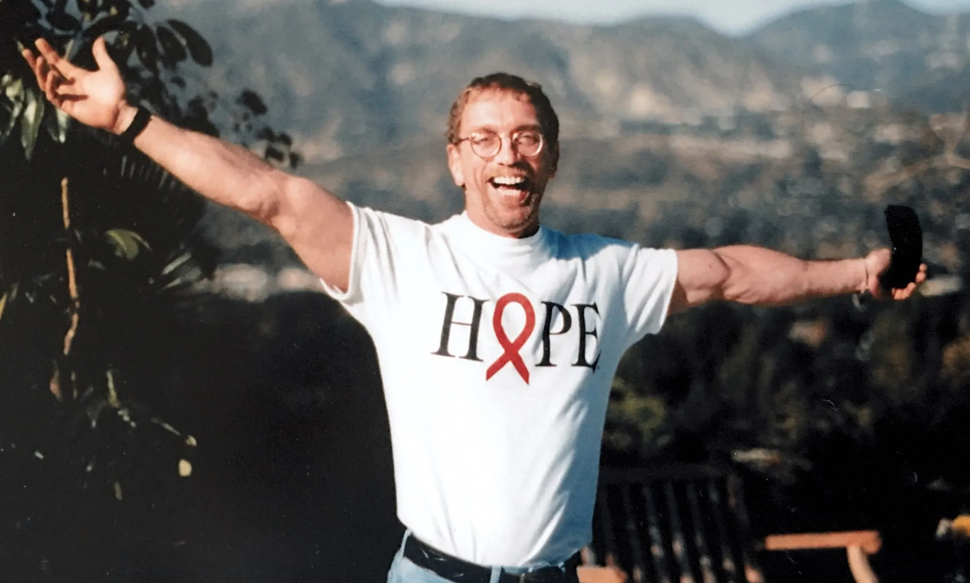 A picture of Steven Pieters, arms outstretched, wearing a Hope t-shirt.