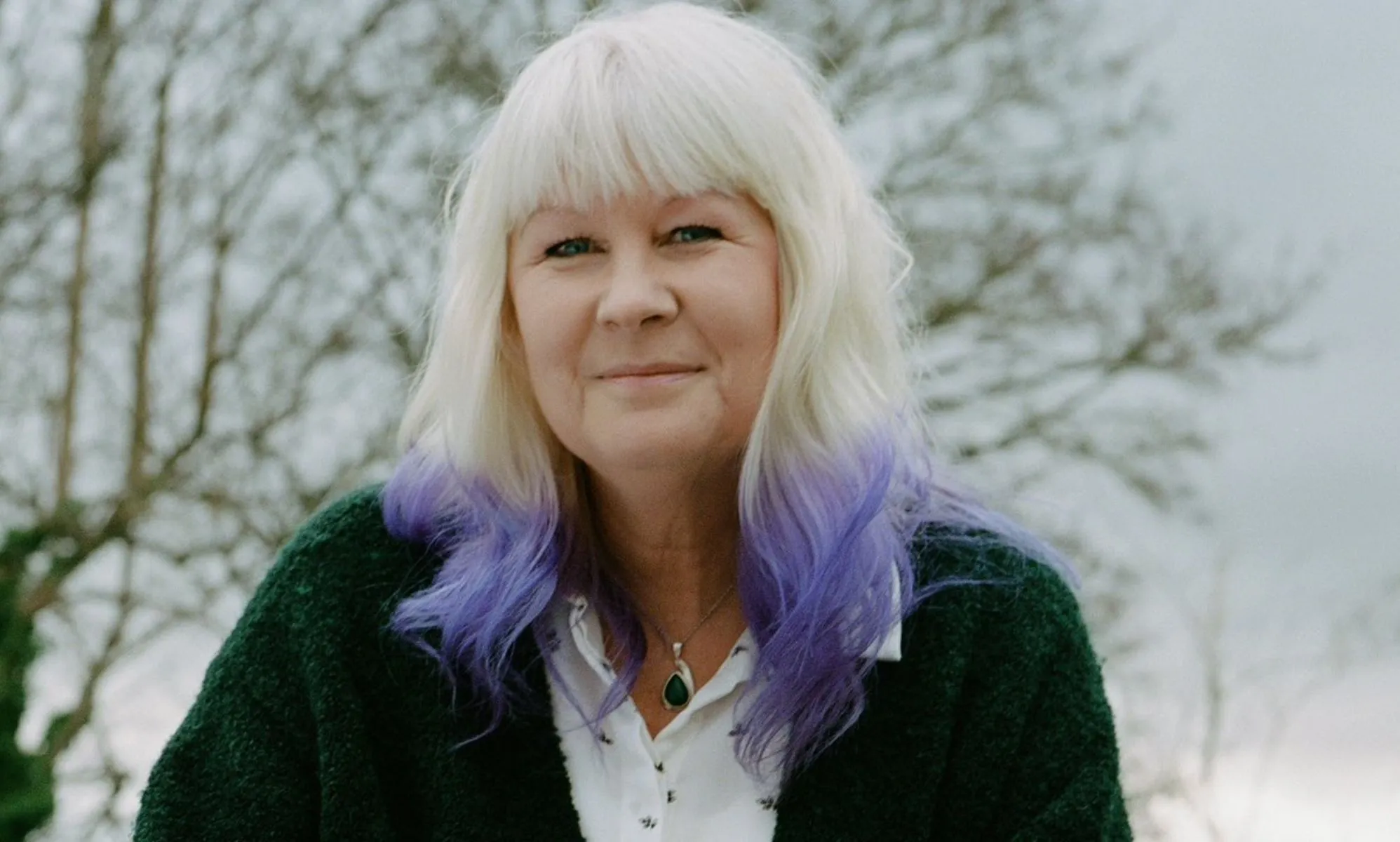 Susie Green outside, wearing a green sweater.