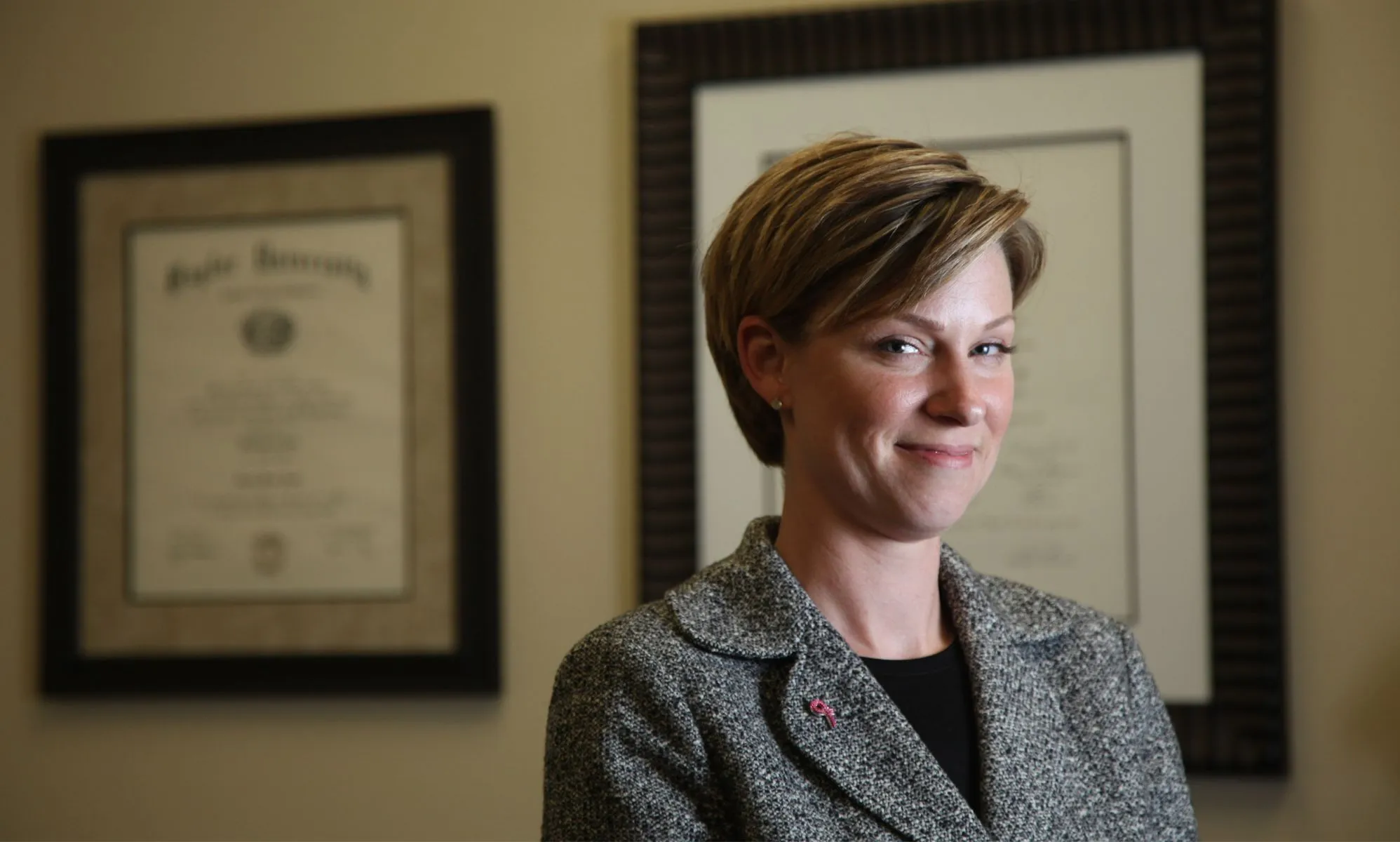 Former Republican Texas state representative Sarah Davis wears a black shirt and dark jacket as she smiles at the camera