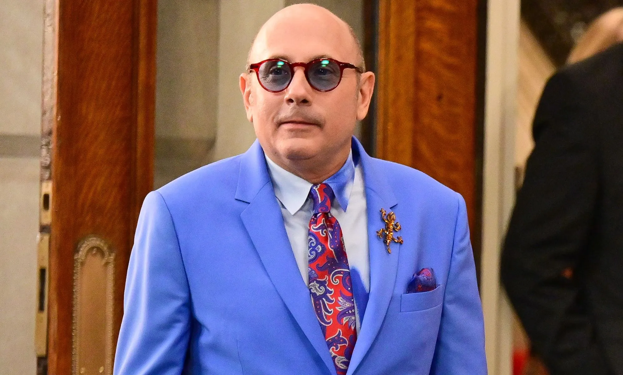 And Just Like That... actor Willie Garson, who played Stanford Blatch, wears a red patterned tie, light shirt and blue jacket while on set