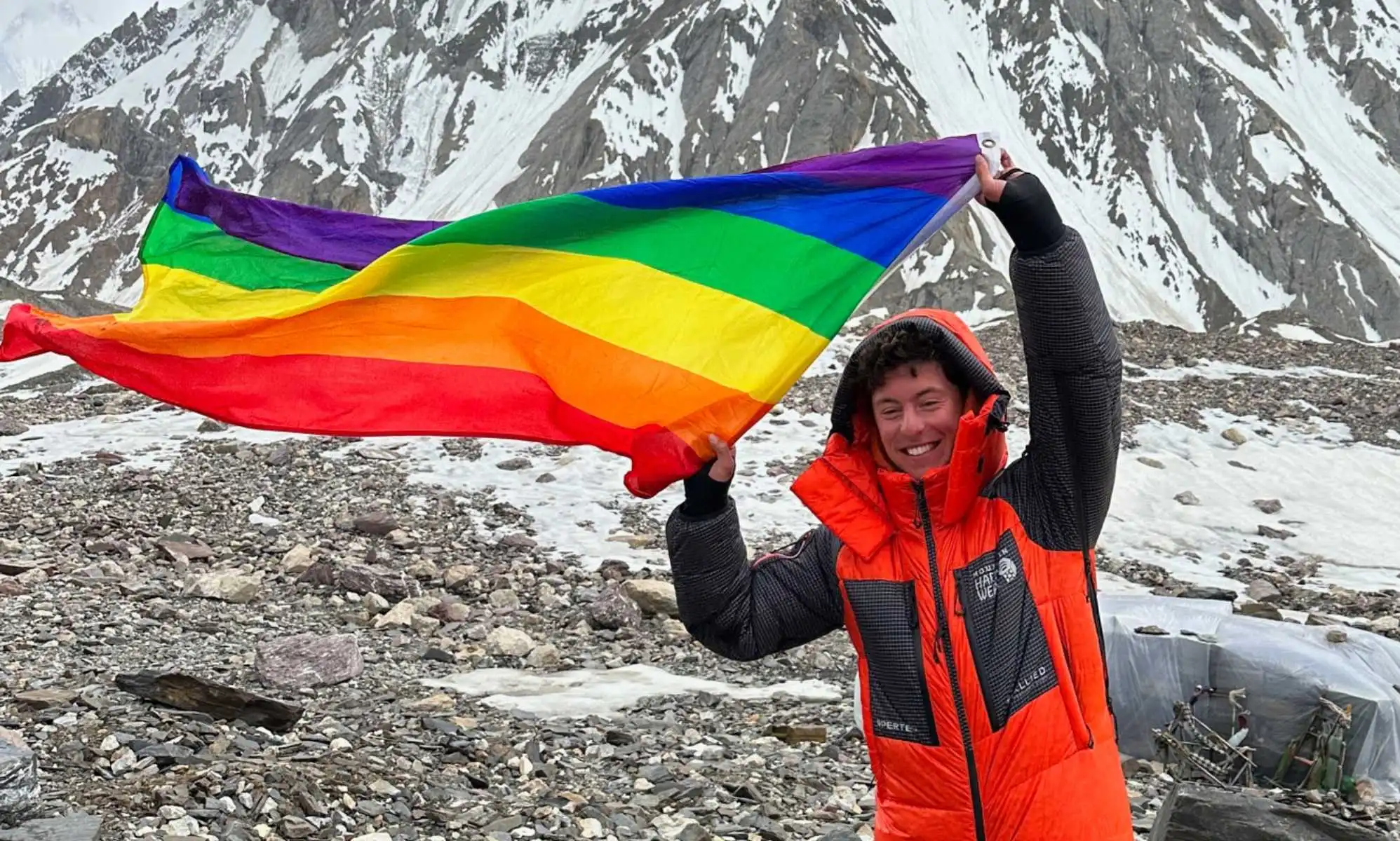 Aidan Hyman waves Pride flag near the summit of the K2 mountain