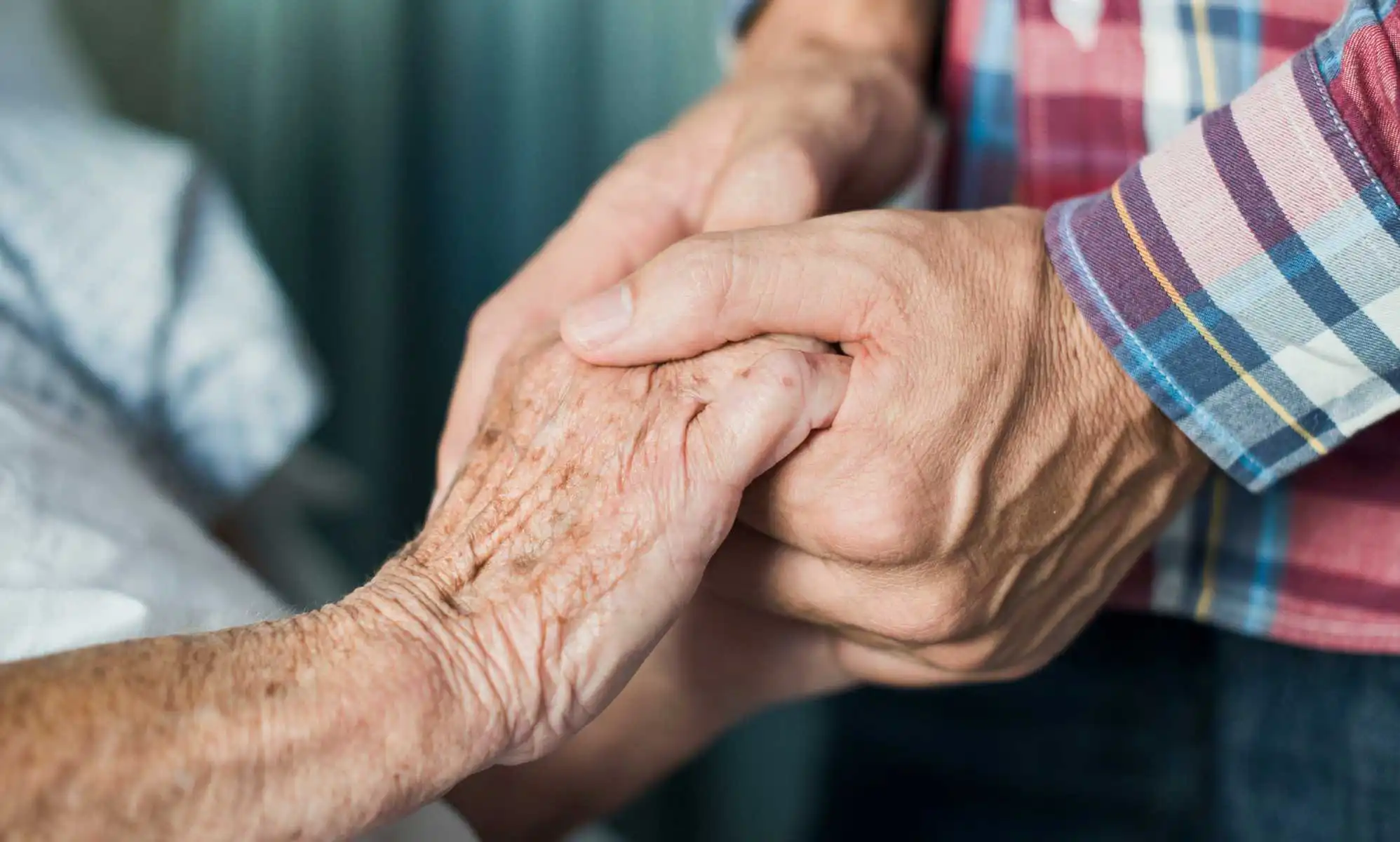 Gay couple hold hands in care home