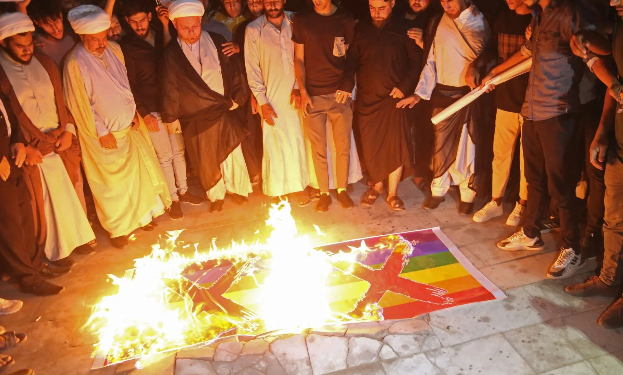 Homophobic protestors in Iraq burn two Pride flags with X