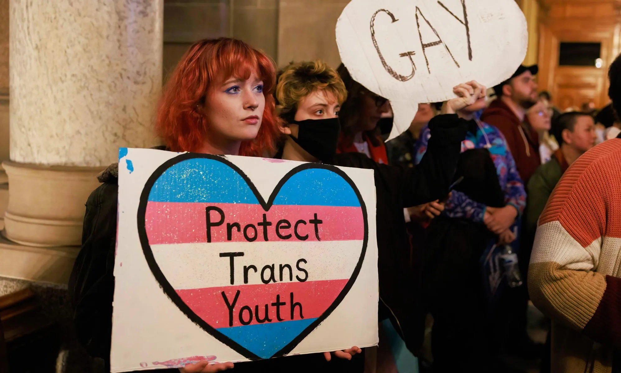An Indiana protestor holds up a card reading