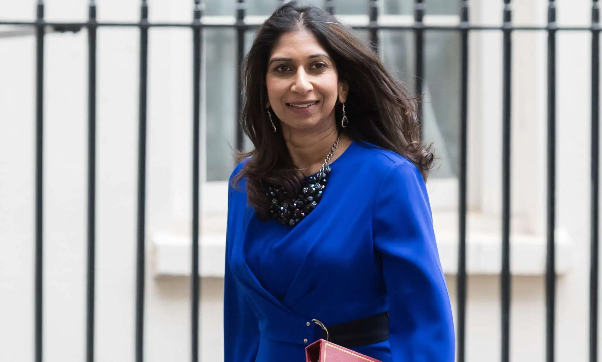 Suella Braverman leaving Downing Street wearing a blue blouse.