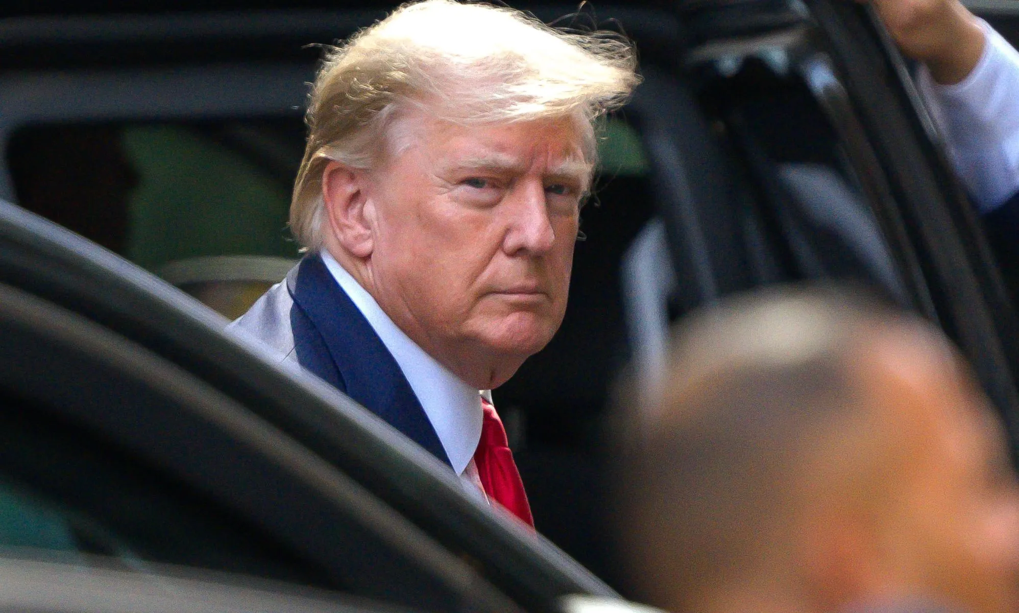 Donald Trump getting out of a vehicle.