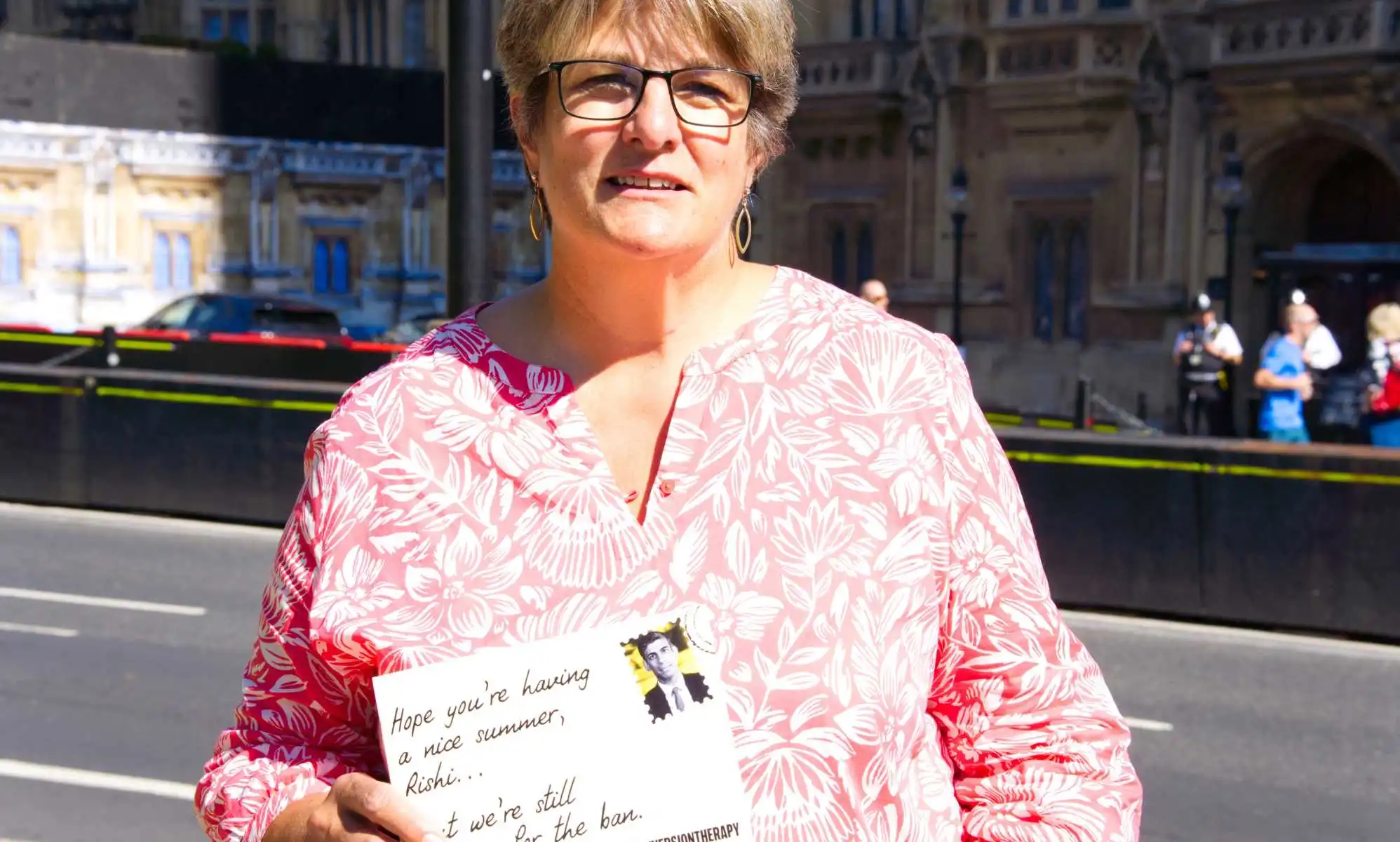 Jayne Ozanne holds postcard up