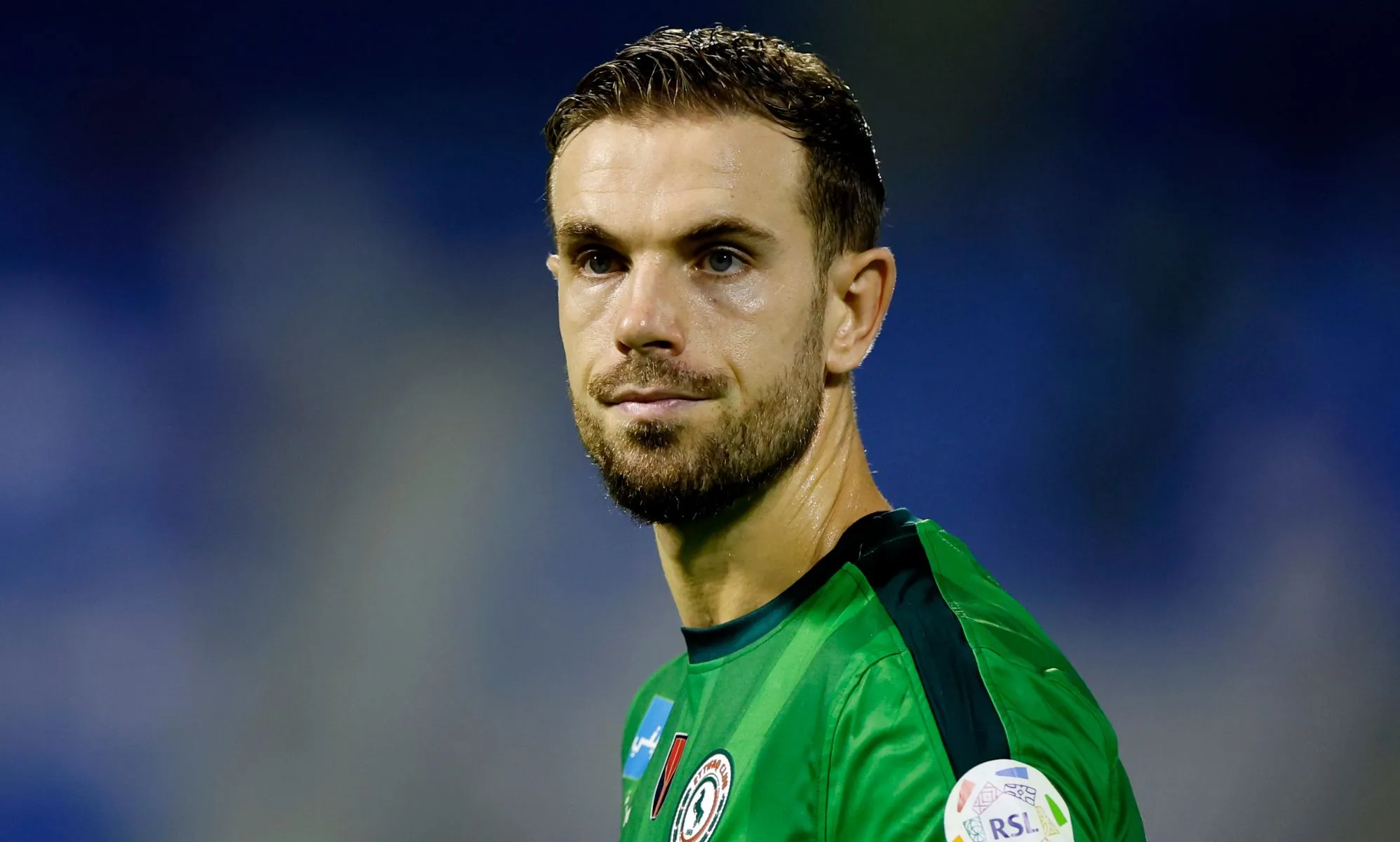 Jordan Henderson during a football match, wearing a green football shirt.