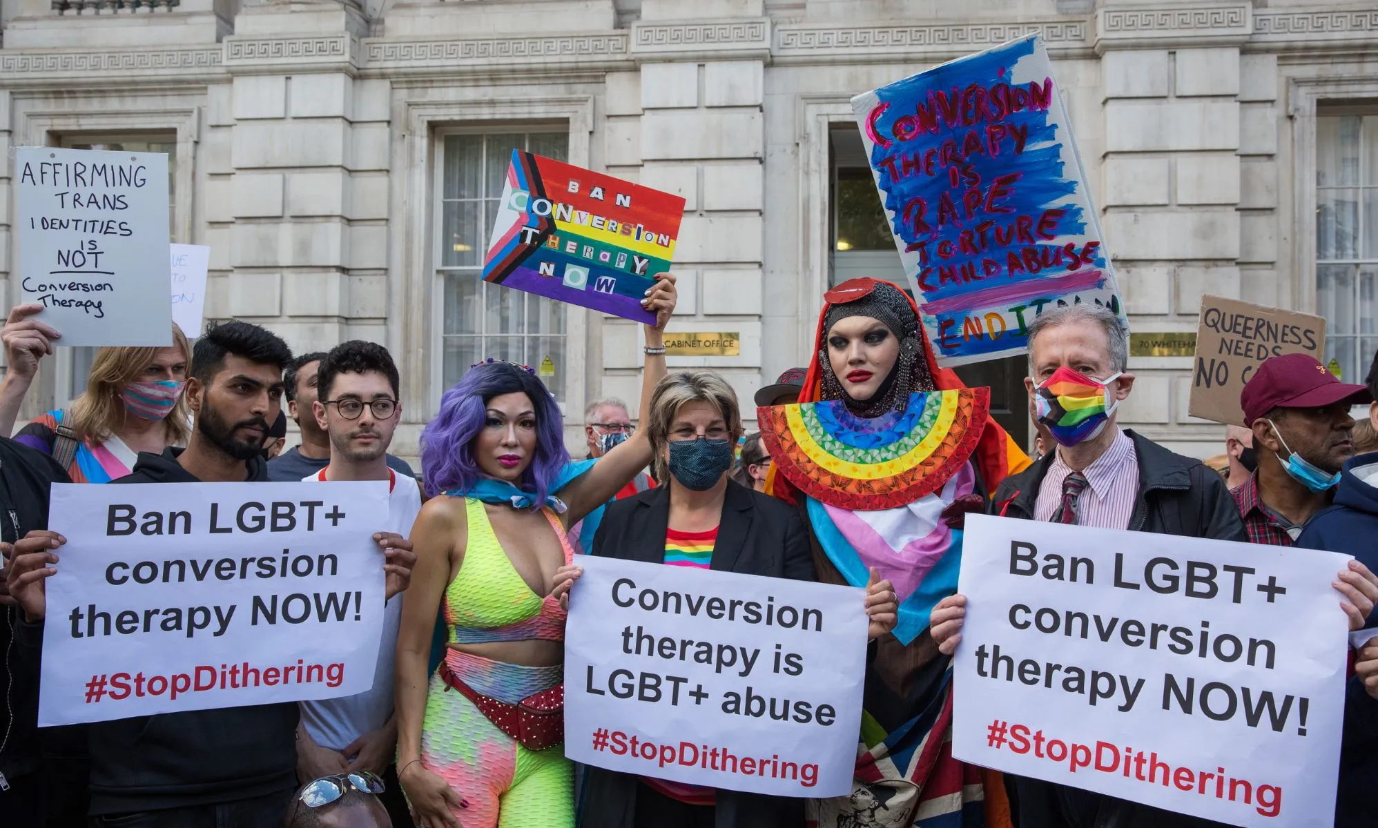 People hold up signs reading
