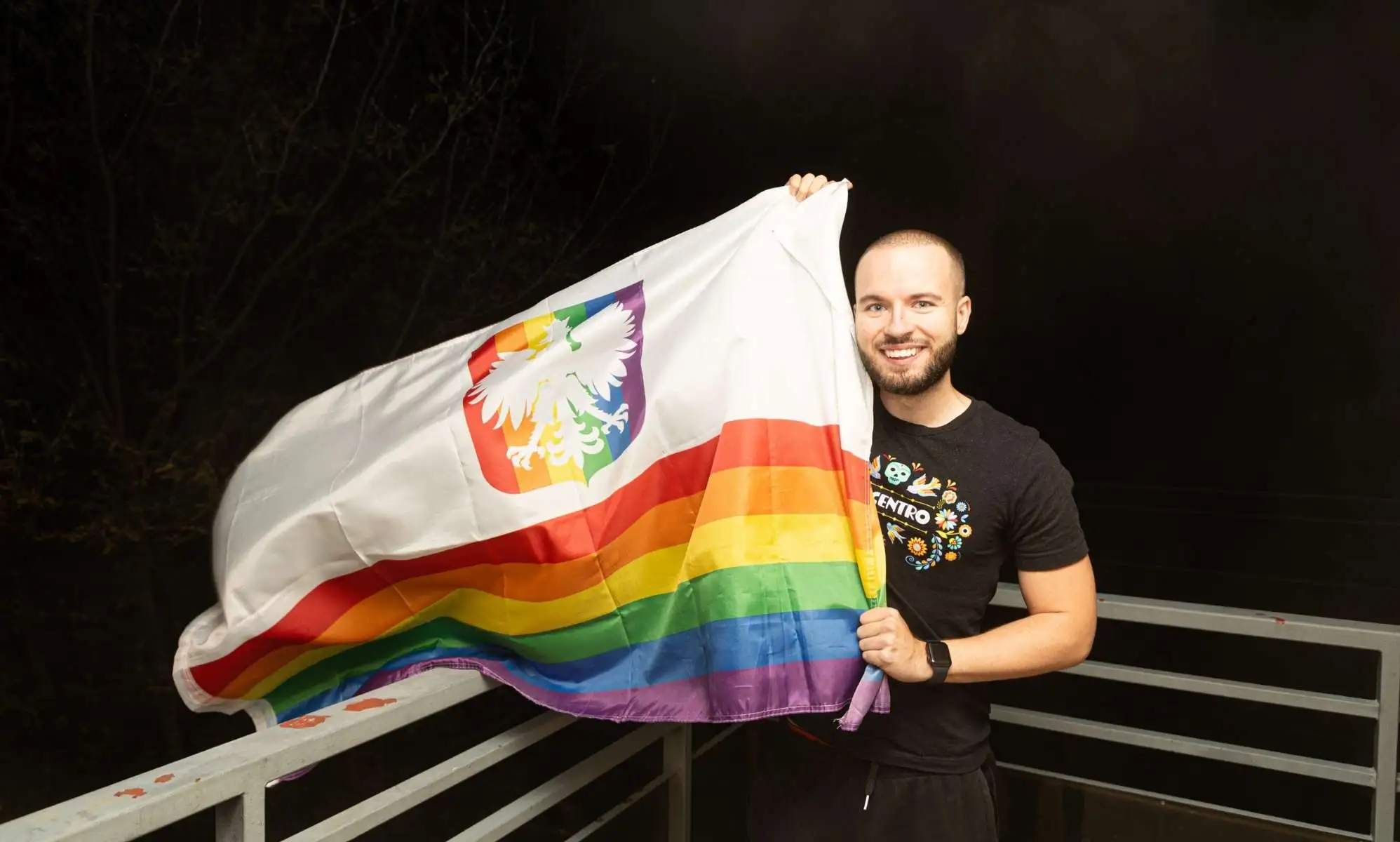 Bart Staszewski pictured holding a Pride flag outside after the election in Poland.