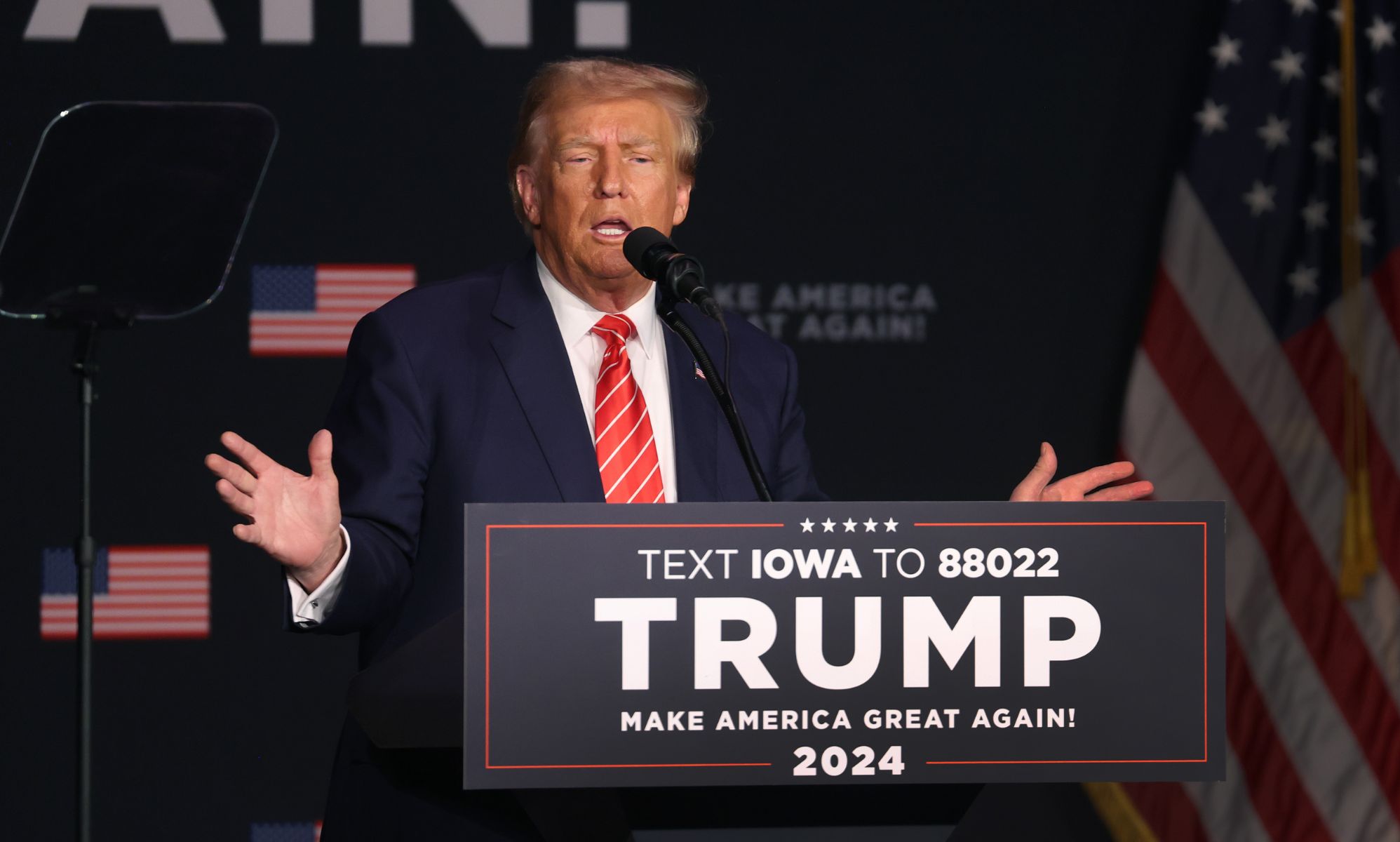 Donald Trump stands behind a podium reading