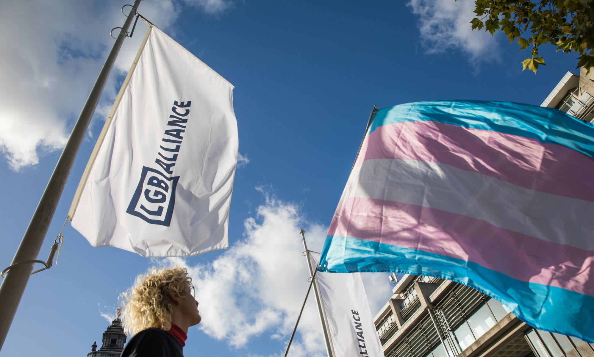 An activist holds a transgender pride flag at a protest by Transgender Action Block and supporters outside the first annual conference of the LGB Alliance at the Queen Elizabeth II Centre on 21st October 2021 in London, United Kingdom.
