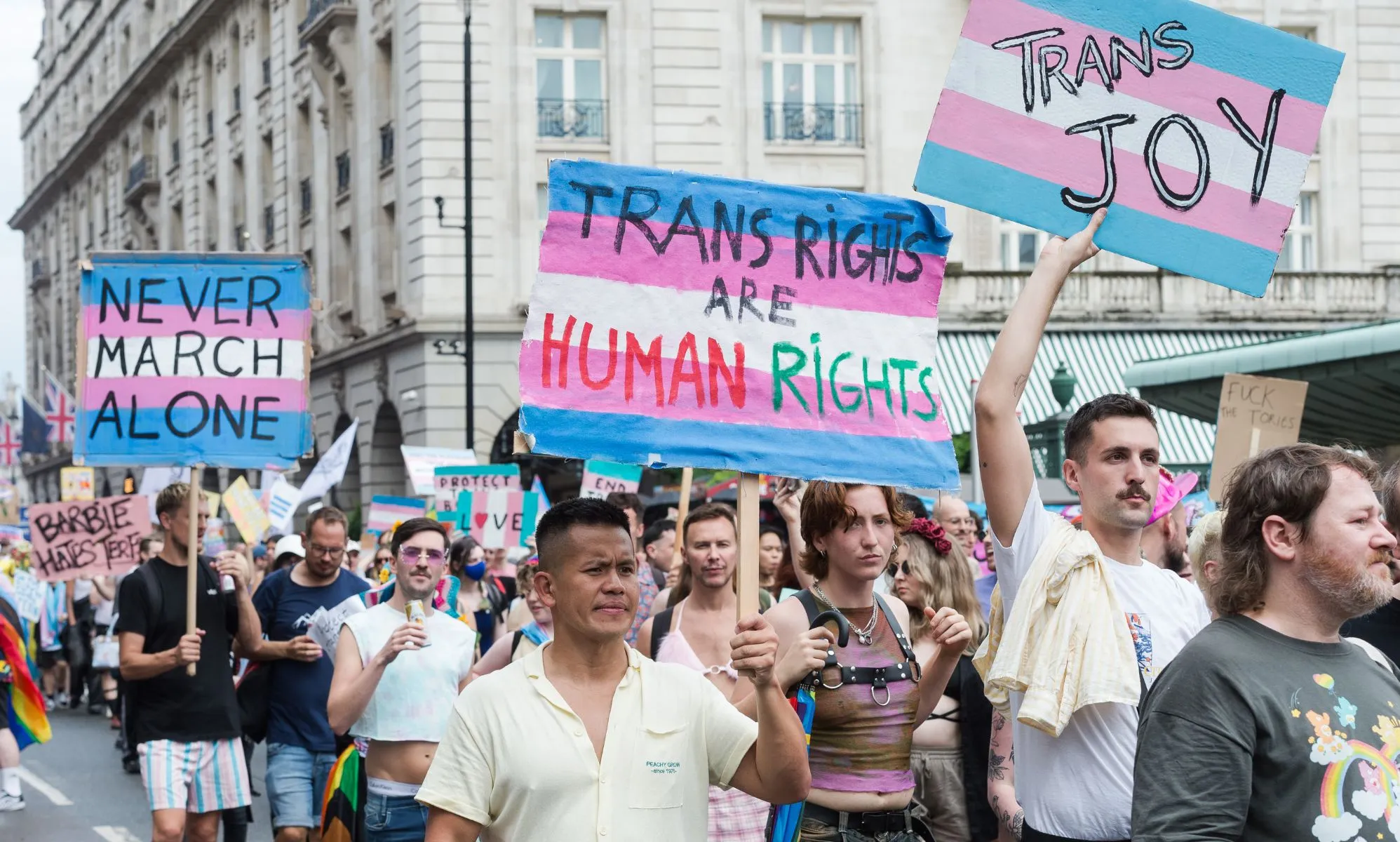 Protesters carry placards reading