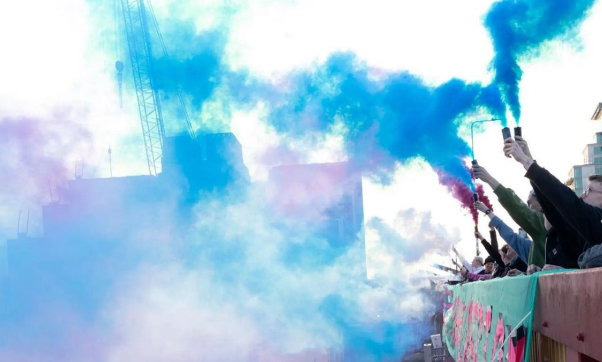 Activists let off smoke bombs in the trans flag colours in protest of the government