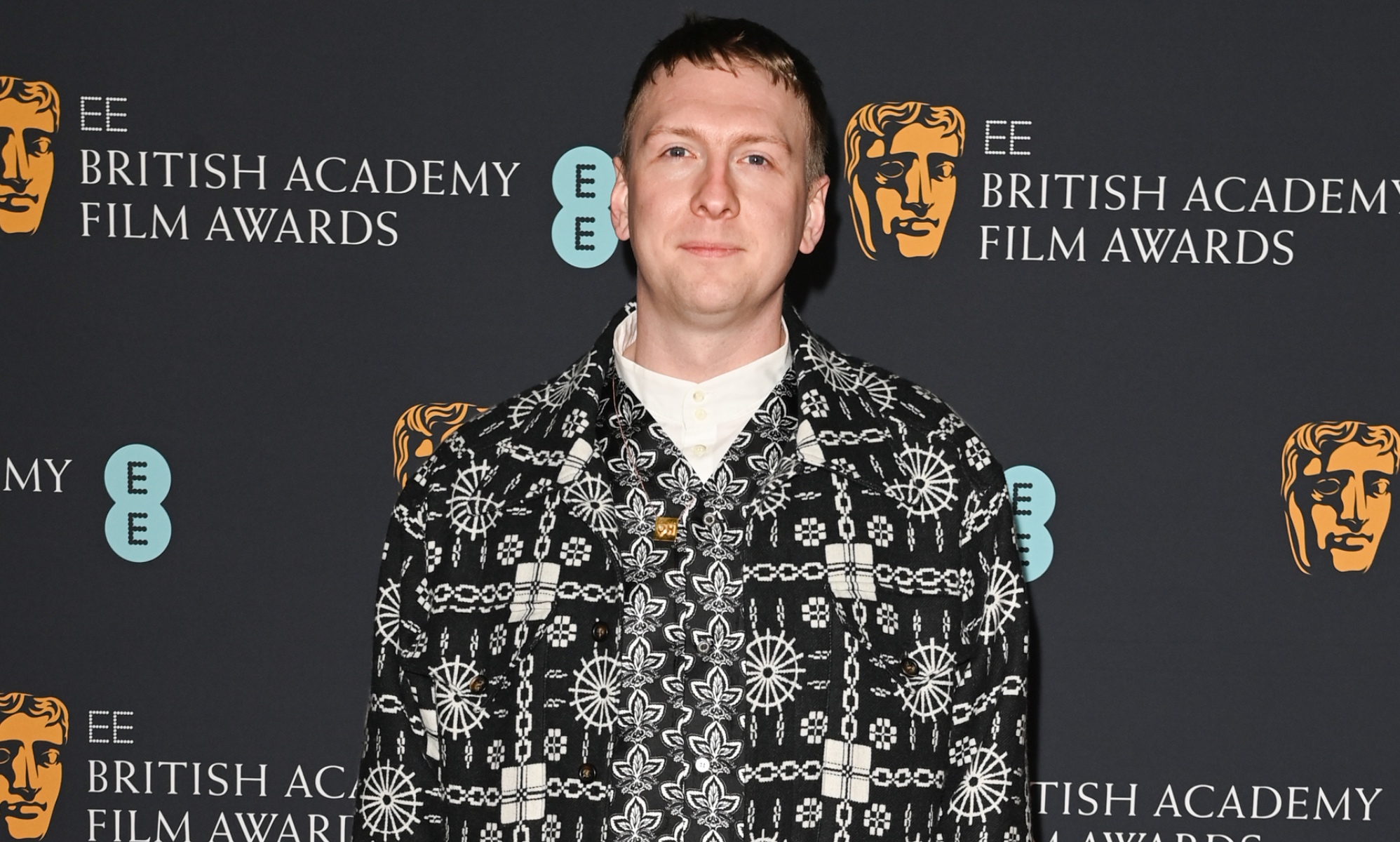 A photo of comedian Joe Lycett wearing a black and white patterned suit jacket over a white top at the Bafta awards ceremony. (Getty)