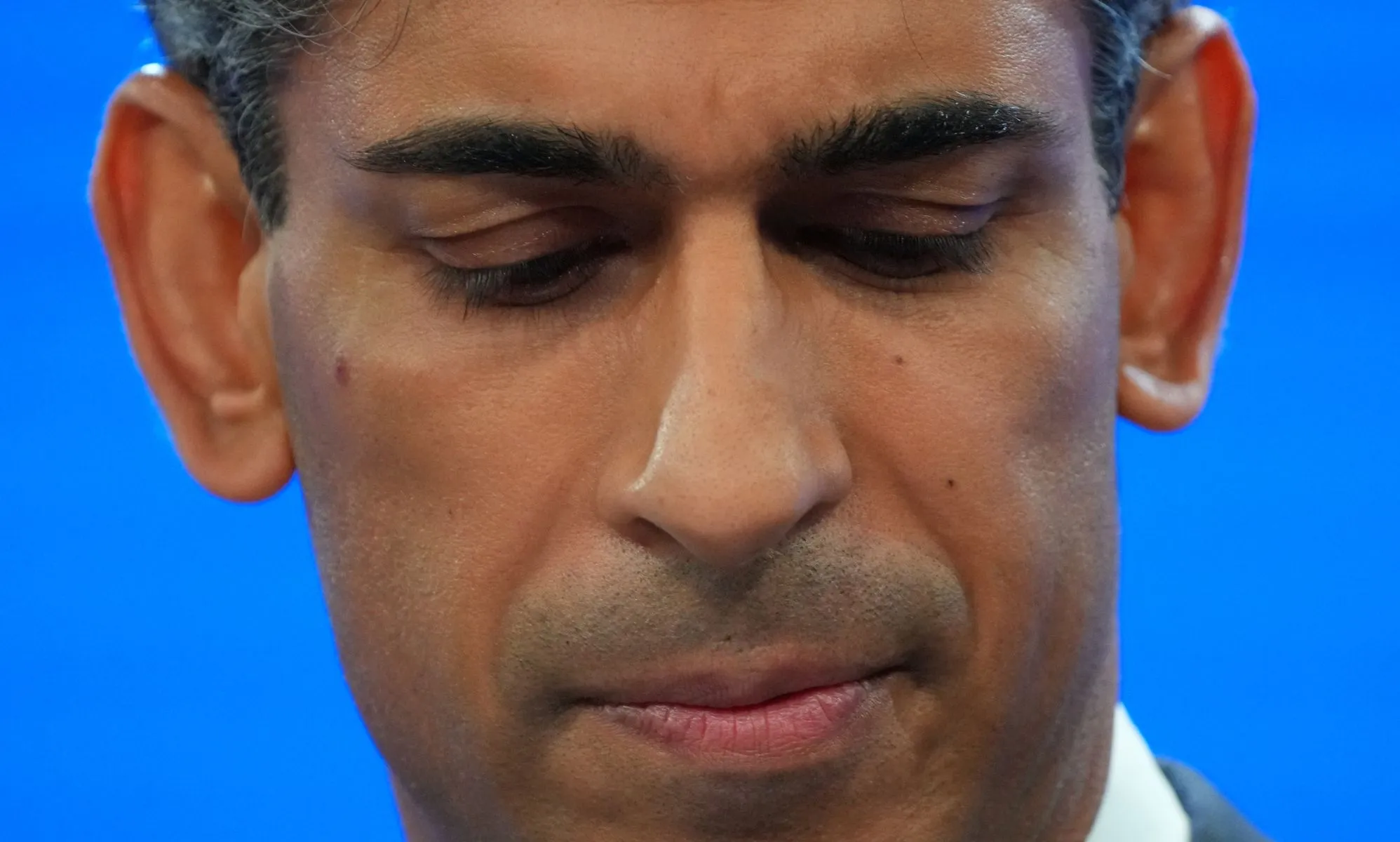 A close up of Rishi Sunak looking down.