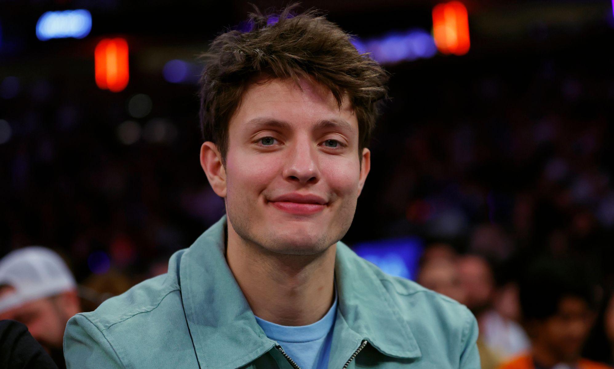 Comedian Matt Rife smiles while wearing a blue shirt.