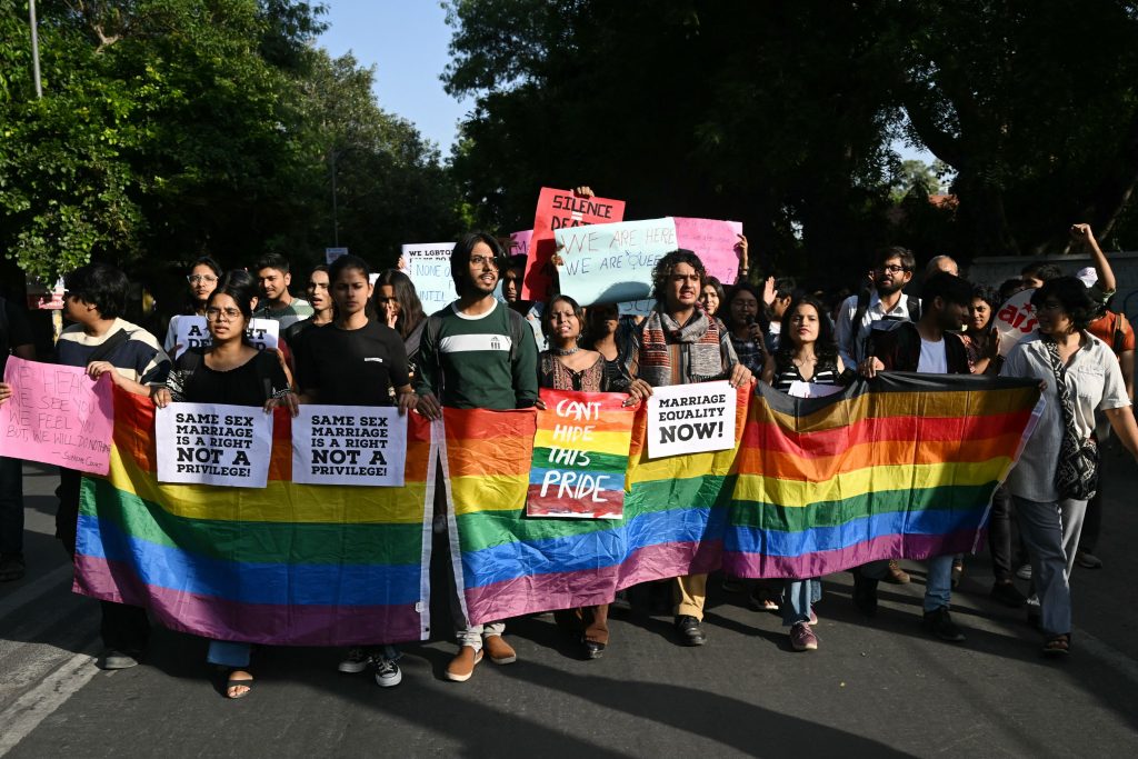 Members of the Student Federation of India (SFI) along with LGBTQ+ activists hold placards and shout slogans during a protest march against India