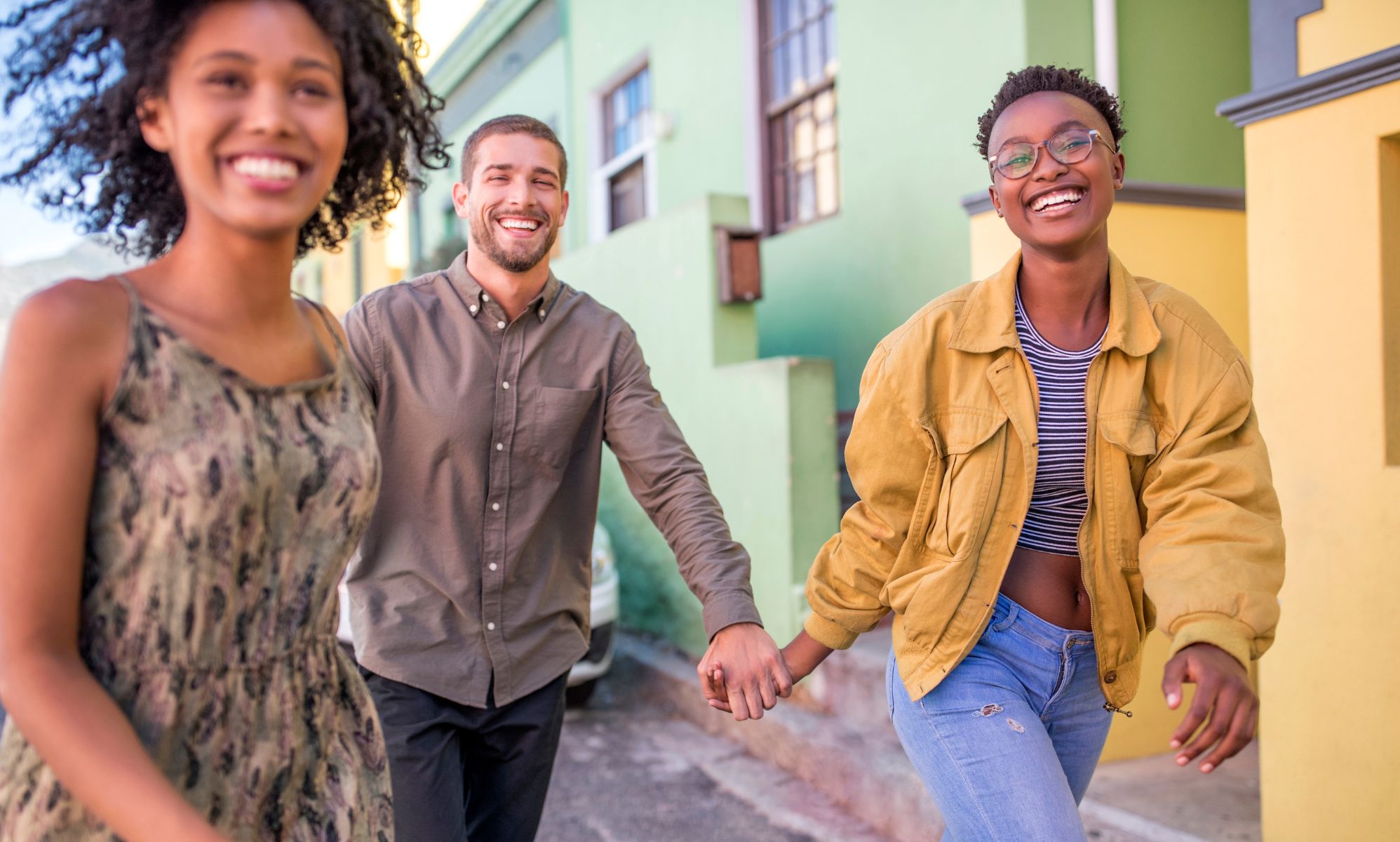 Three people walking down the street to symbolise a polyamorous relationship