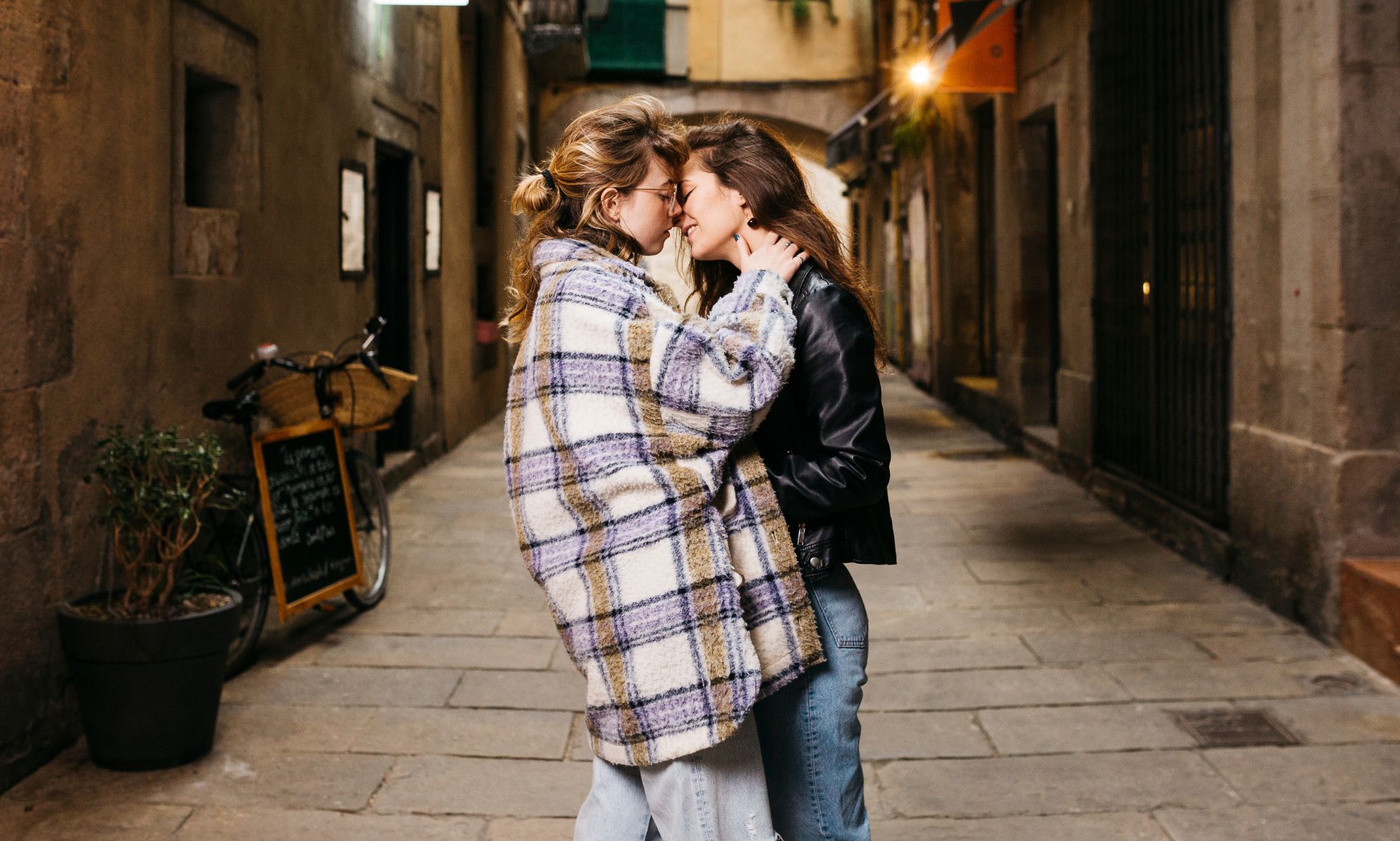 Stock image of two women kisses on an alley street