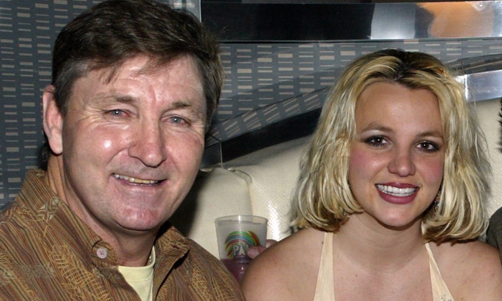Jamie Spears in a brown jacket and Britney Spears in a vest smile at the camera