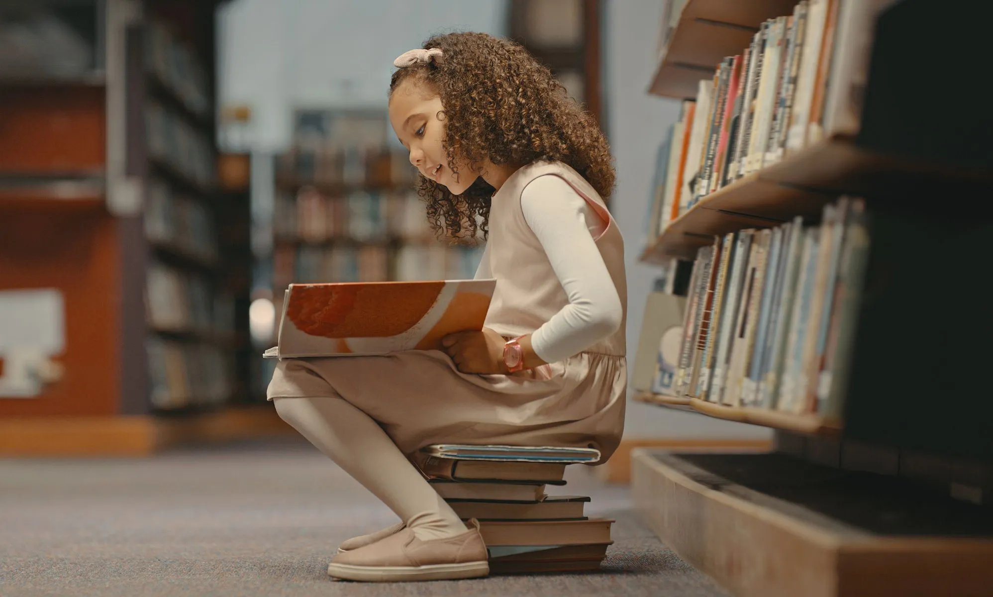 Girl reading a book in a library