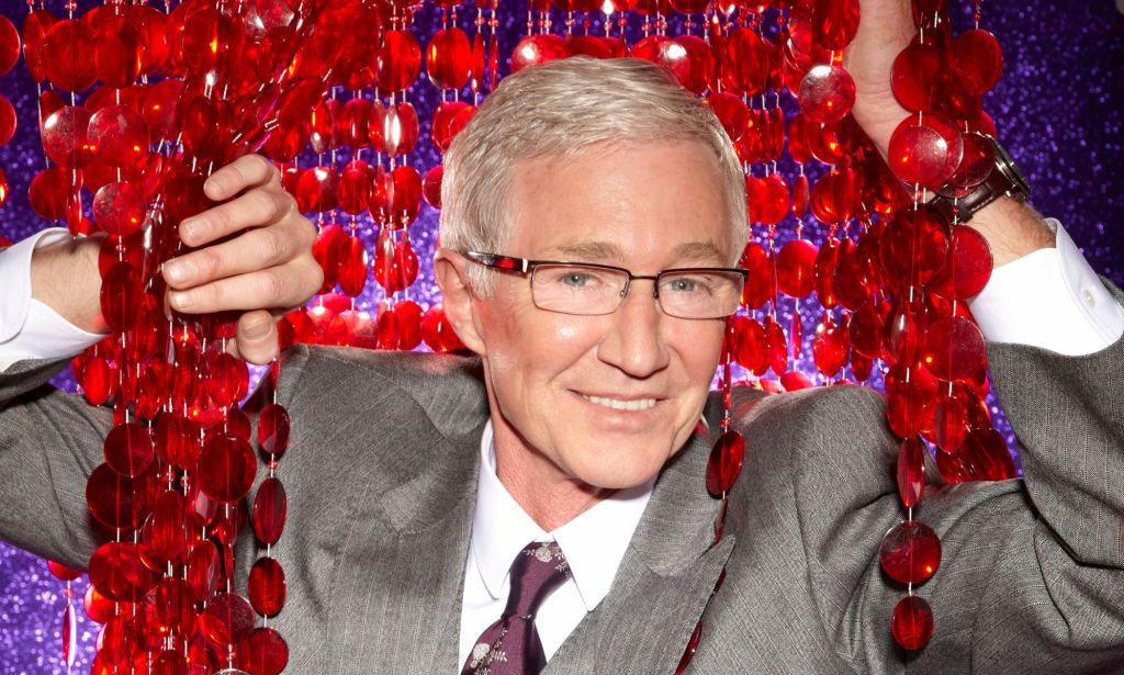 Paul O'Grady viste un traje gris mientras posa con superficies reflectantes.  Está entre las estrellas y aliados LGBTQ+ que murieron en 2023.