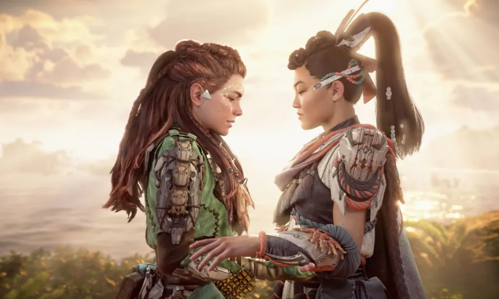 Una captura de pantalla del videojuego Horizon Forbidden West Burning Shores del personaje LGBTQ+ Aloy de pie del brazo de otro personaje femenino a quien besó.