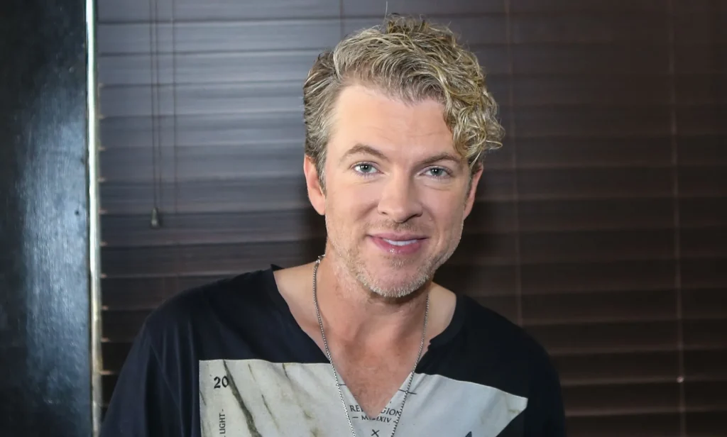 Joe Don Rooney smiling in a black and grey top.