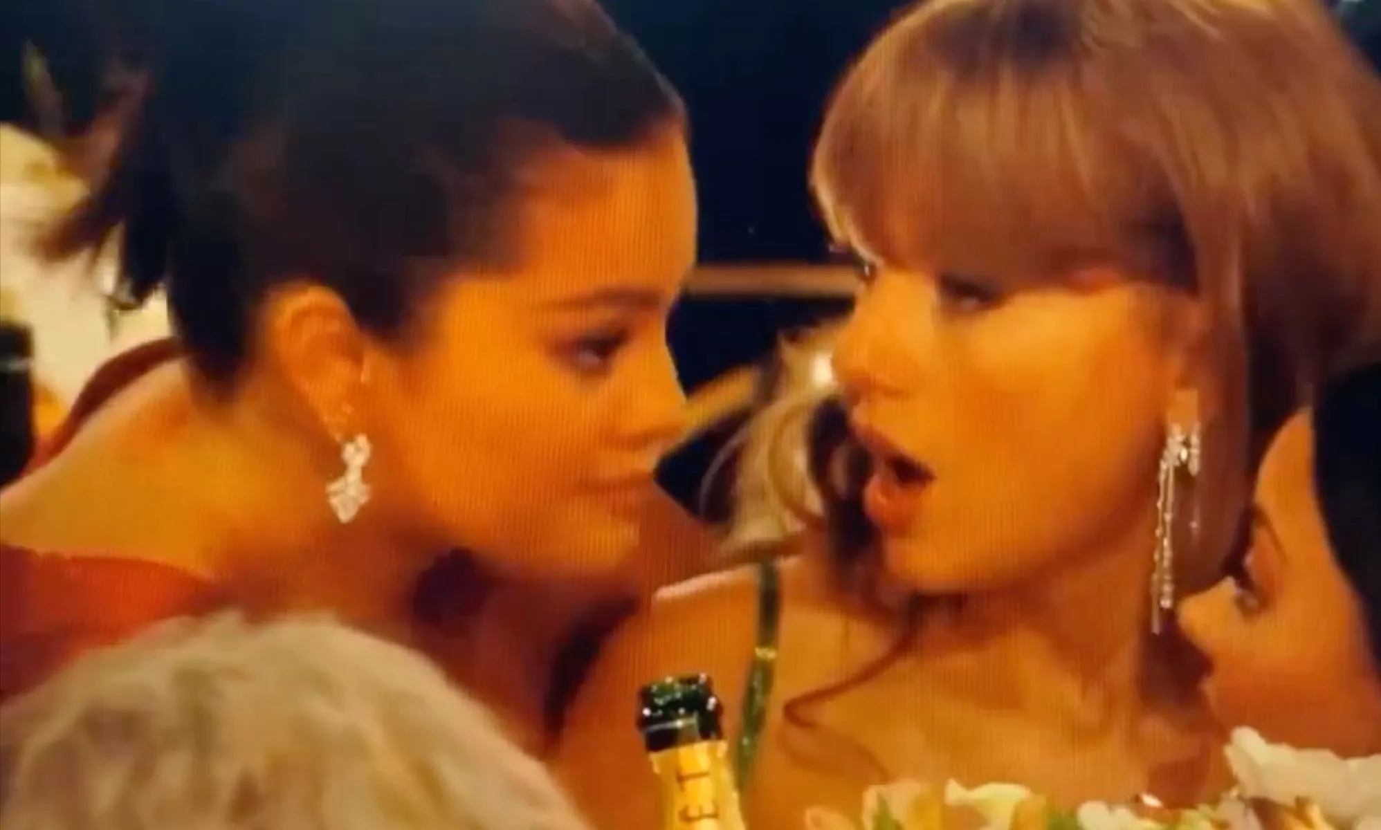 Selena Gomez leans down to talk to Taylor Swift during a now viral interaction at the 2024 Golden Globes