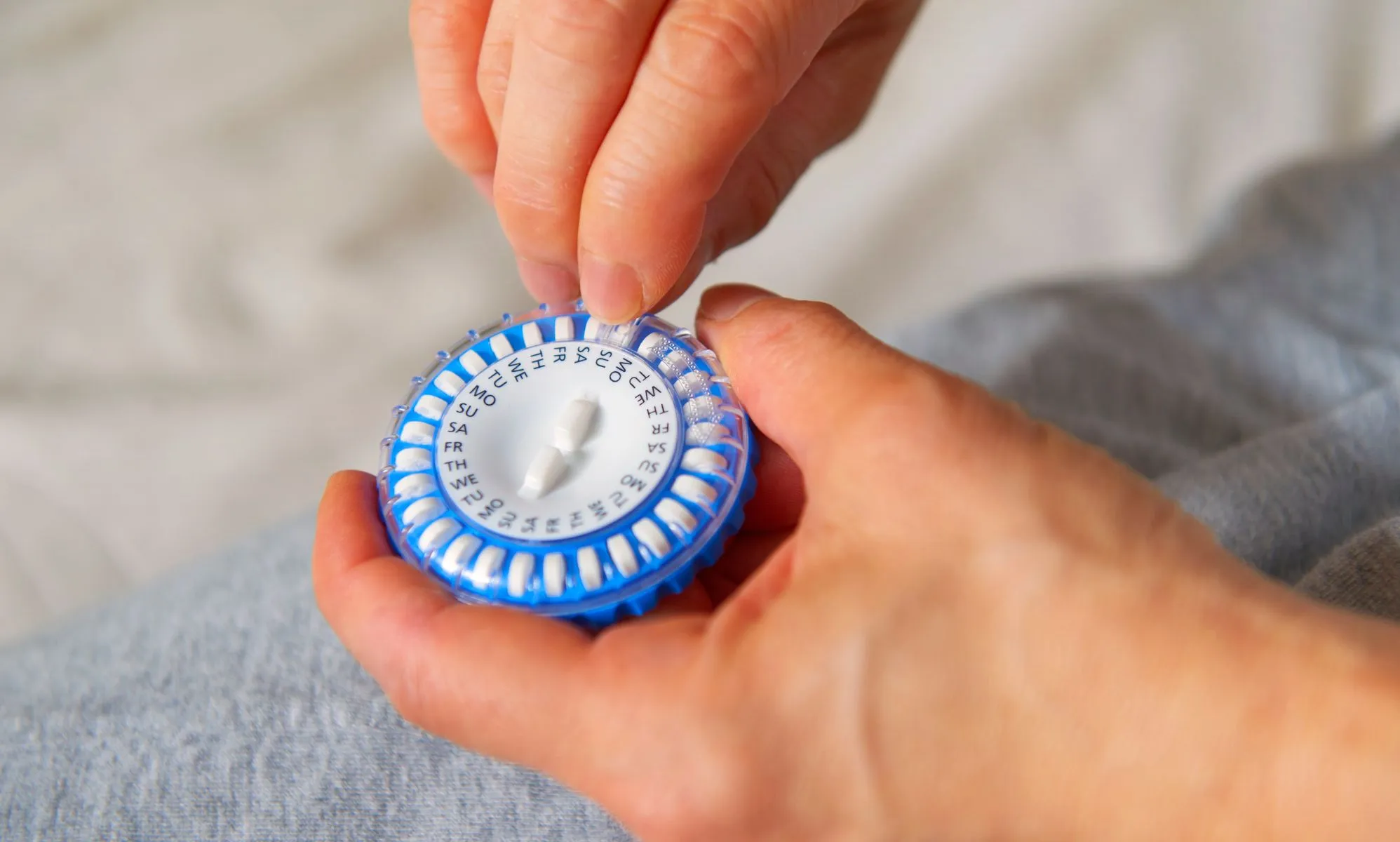 A person picks a pill out of a HRT capsule.