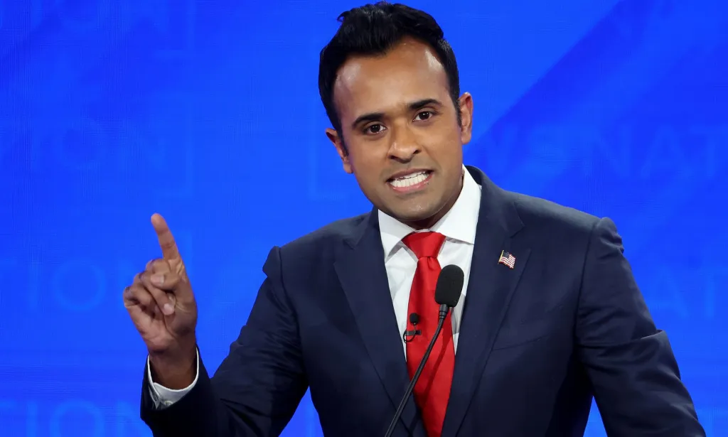 Vivek Ramaswamy, quien ha sido sugerido como candidato a vicepresidente de Donald Trump, viste traje y corbata mientras hace gestos con una mano durante un debate presidencial republicano.