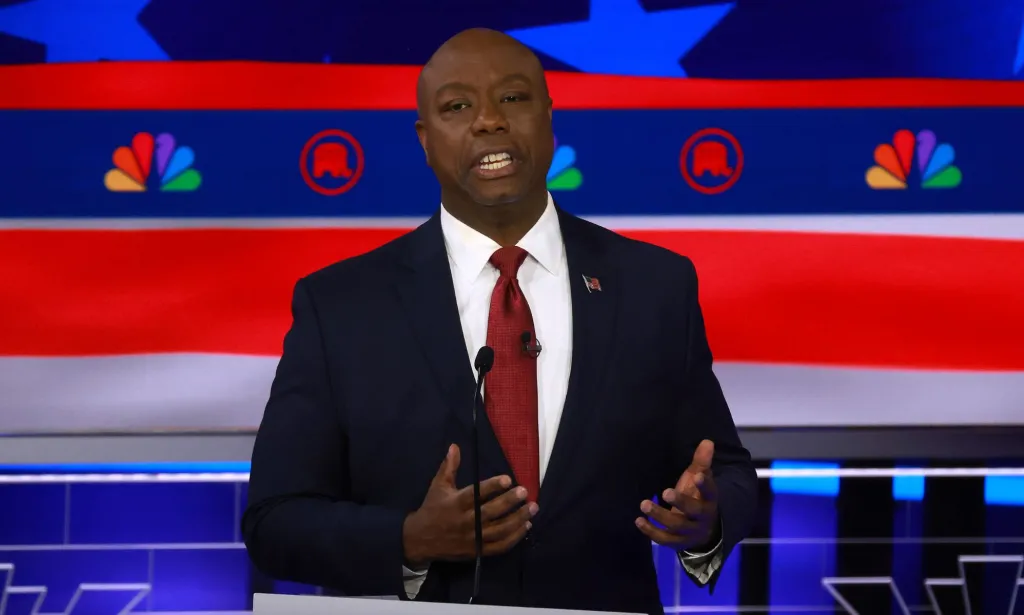 El senador de Carolina del Sur, Tim Scott, quien ha sido sugerido como vicepresidente de Donald Trump, viste traje y corbata mientras habla durante un debate presidencial republicano.