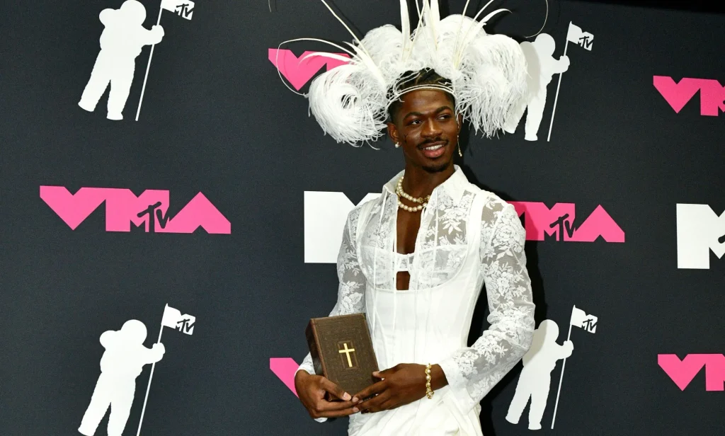 Lil Nas X poses with a bible in the press room at the 2023 MTV Video Music Awards