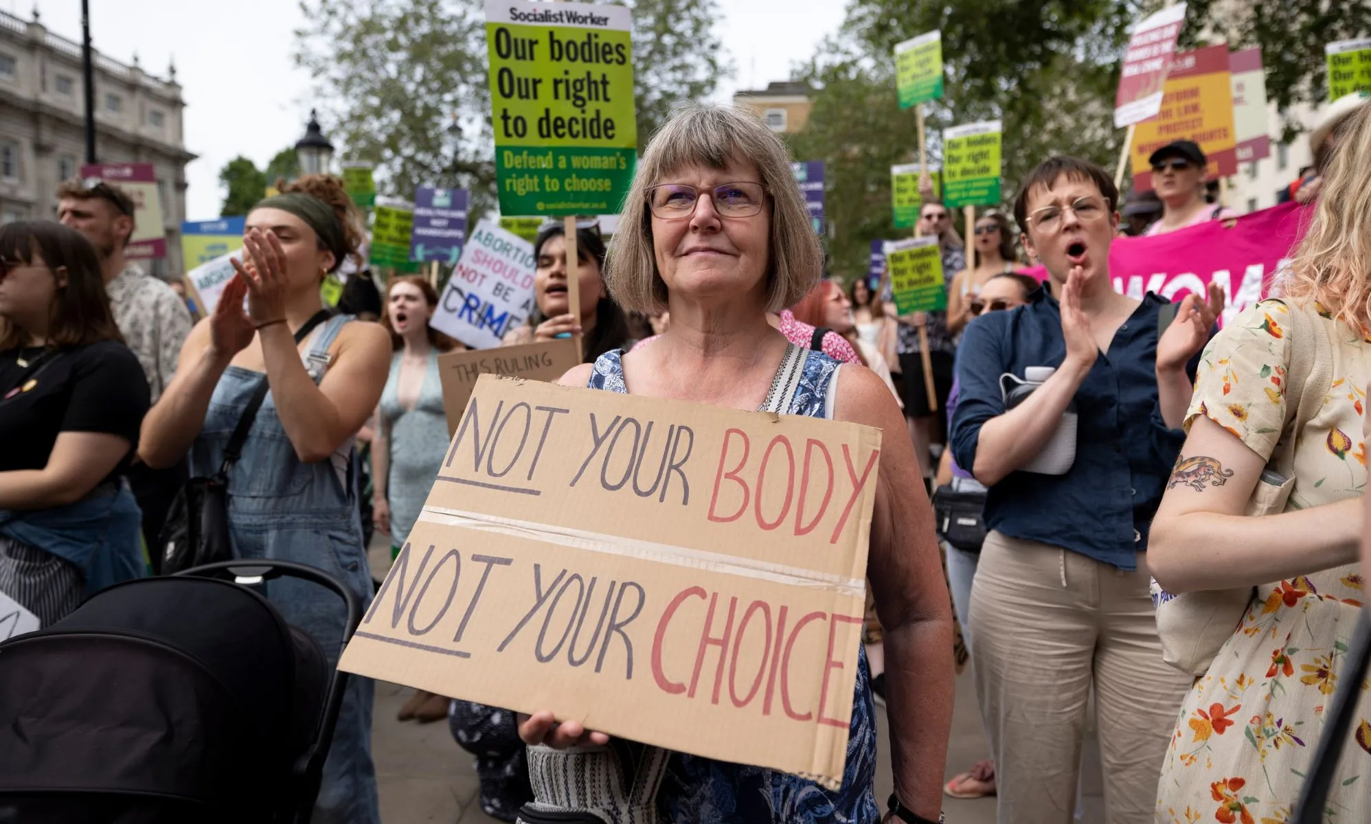 A protester stands with a pro-choice placard supporting legal abortion. The placard reads