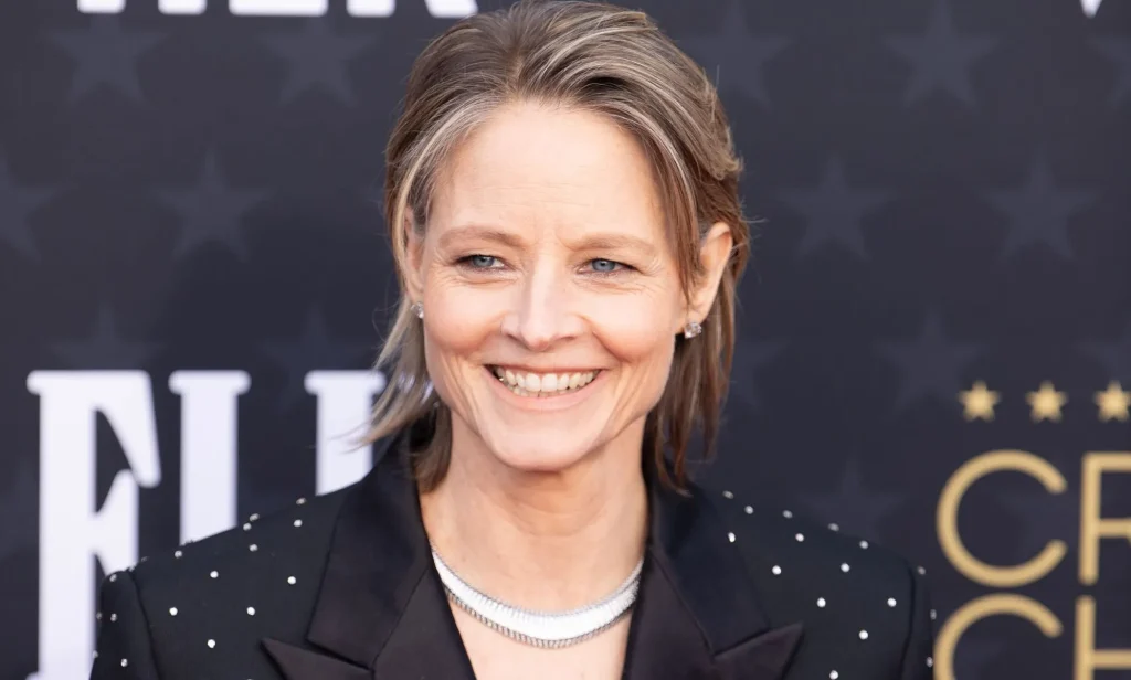Actor Jodie Foster, who was once offered to play Princess Leia in Star Wars, smiles as she wears a black jacket with sparkly designs on it and a shiny silver necklace