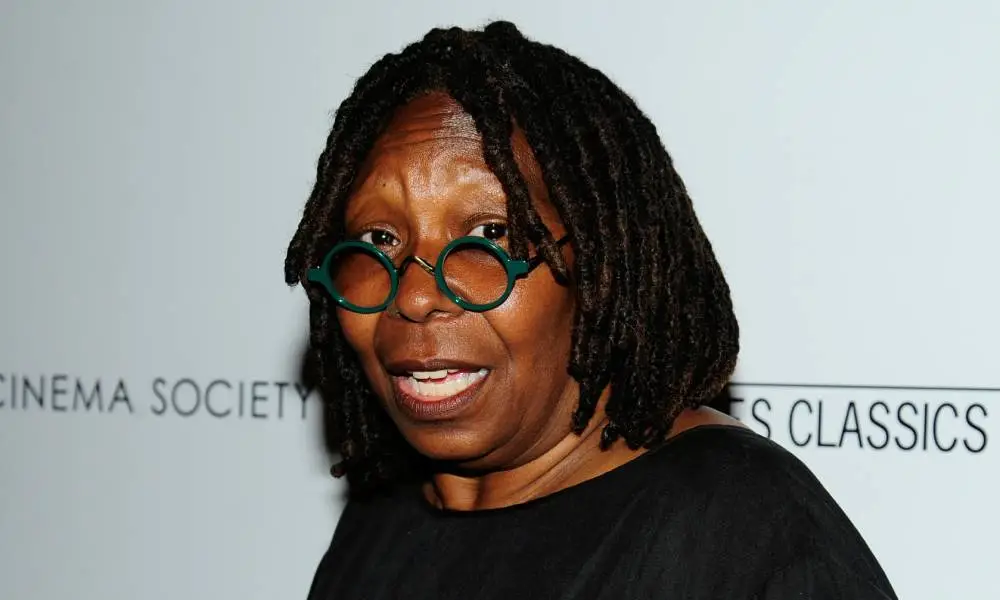 Whoopi Goldberg con gafas redondas y un top negro