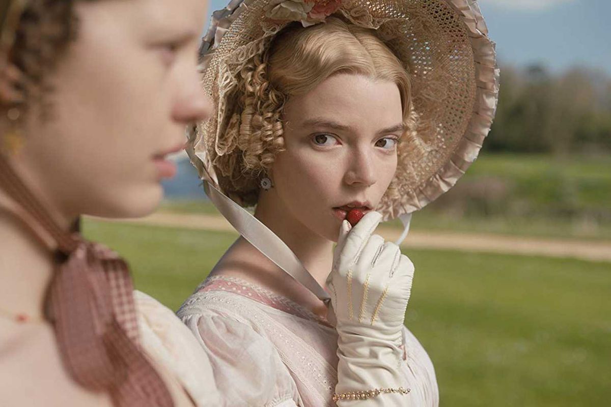 A scene from the 2020 Jane Austen film Emma, showing Emma - played by Anna Taylor-Joy – gazing at her friend Harriet (Mia Goth) while sitting on a bench outdoors