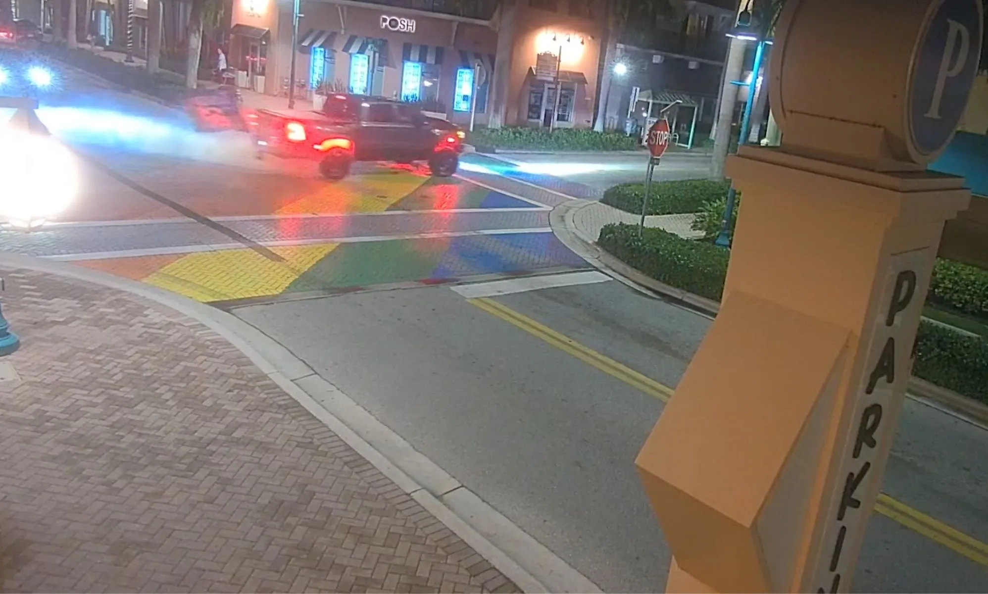 A dark coloured truck burns tire marks into a rainbow coloured crosswalk memorial dedicated to the victims and survivors of the Pulse nightclub shooting in Florida