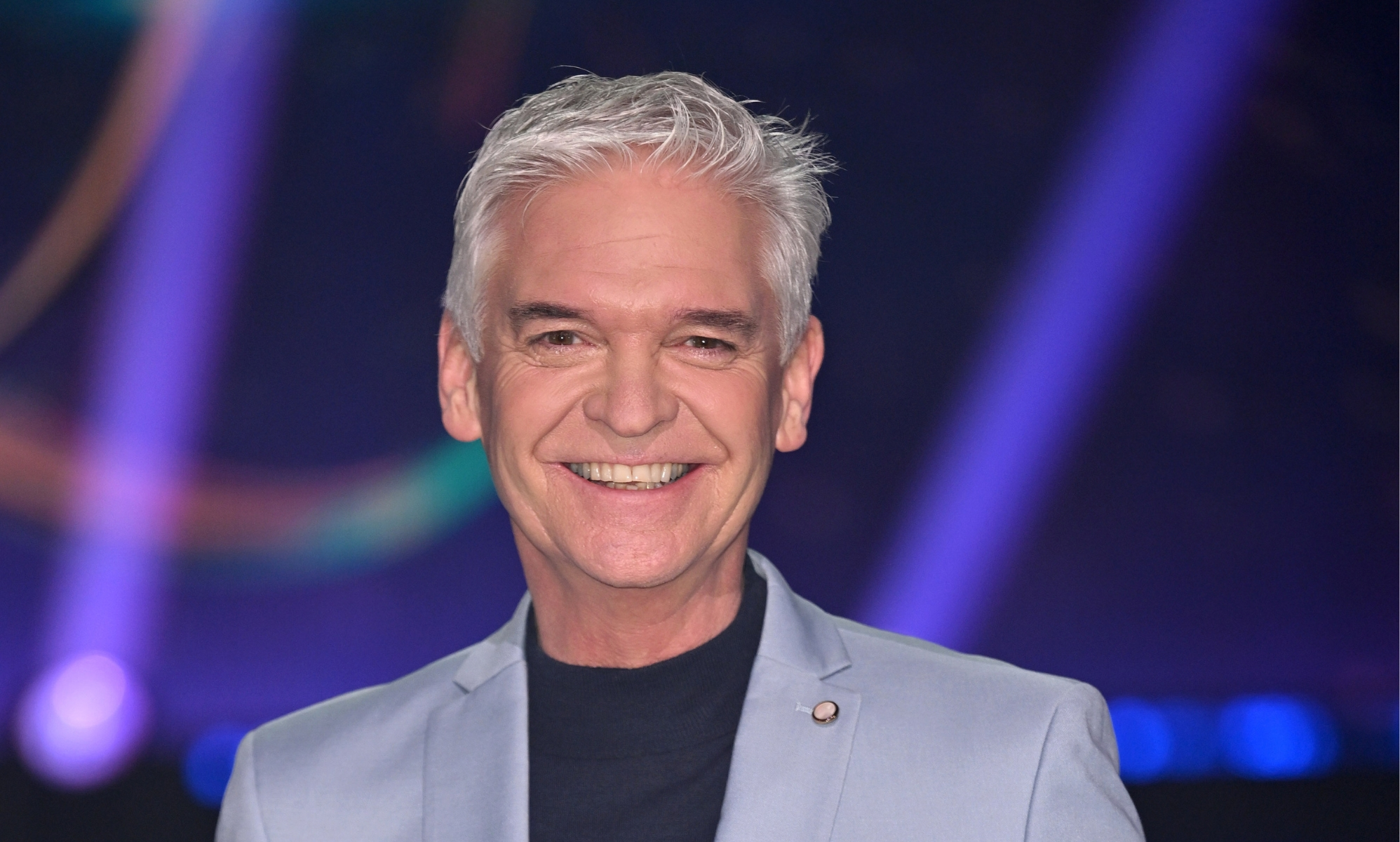 Philip Schofield smiling in a light blue suit.