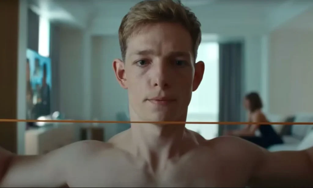 Mike Faist shirtless in a still from Challengers. He looks solemn.