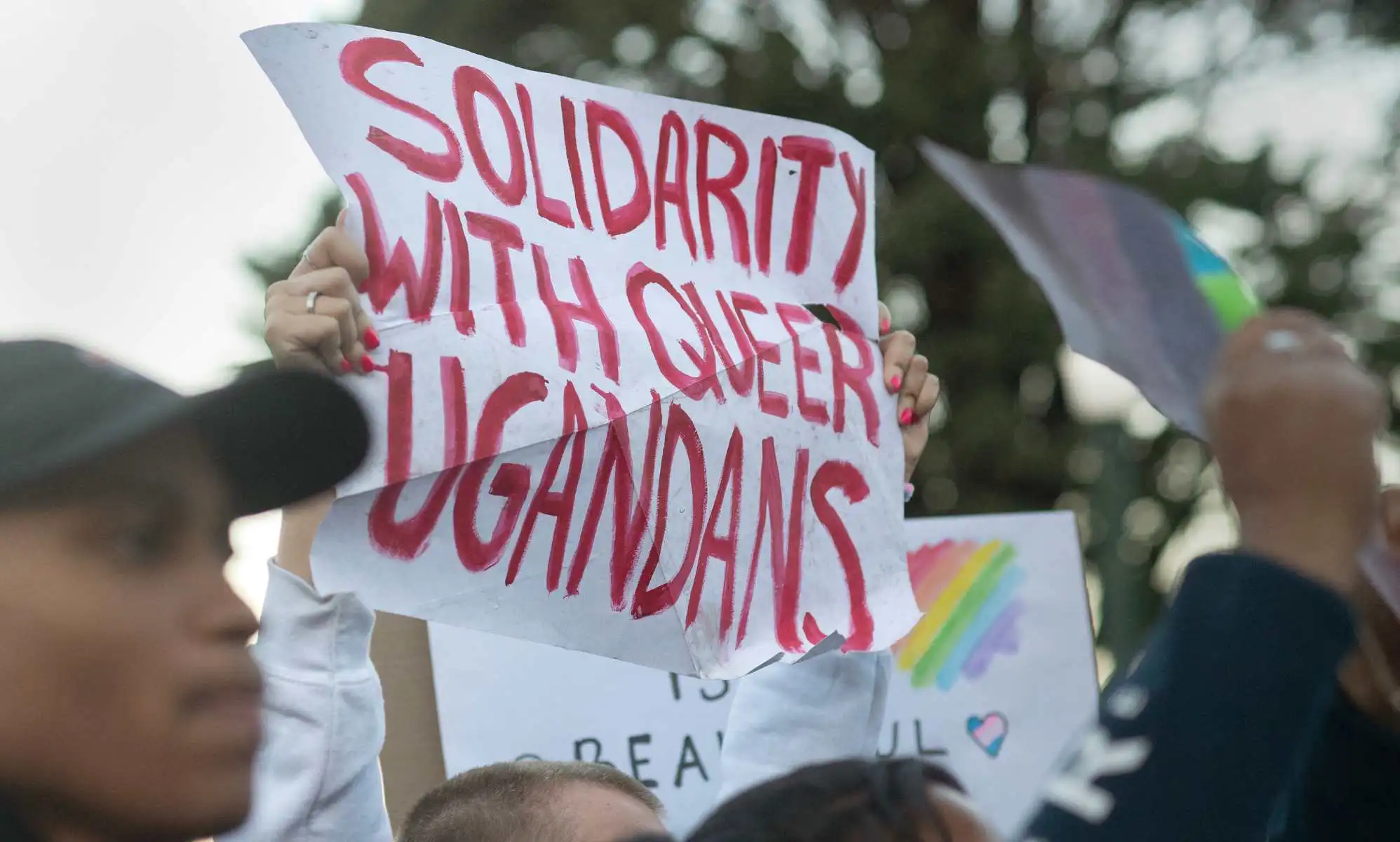 Protesters waves placards while joining supporters of the LBTQ community as they stage a protest against a planned lecture by Kenyan academic Patrik Lumumba (not visible) at the University of Cape Town on July 24, 2023. Lumumba, who has been invited to address a keynote speech by the South African opposition party Economic Freedom Fighters, has been contested because of his views on homosexuality and his support for Uganda