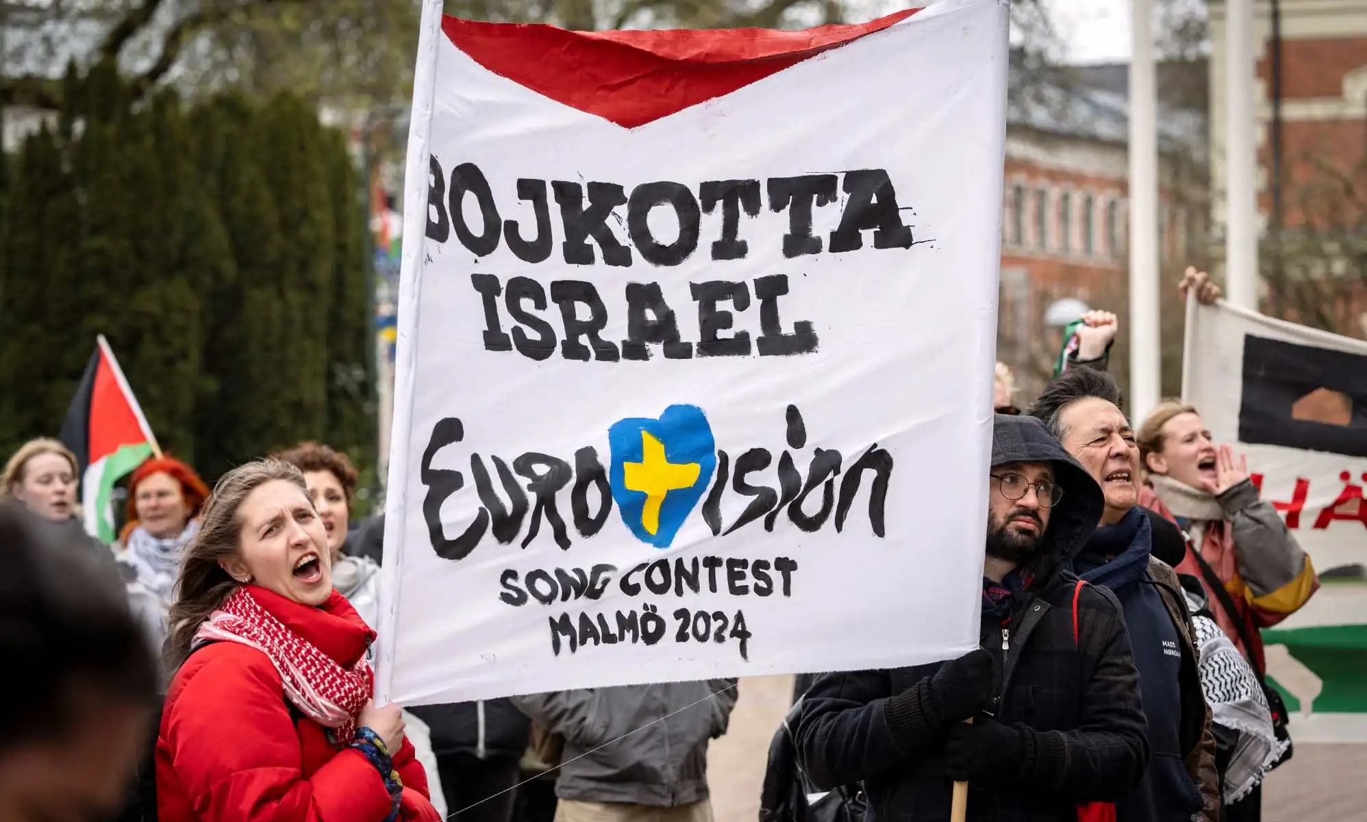 Participants hold up flags and placards during a demonstration outside the City Hall in Malmö, Sweden on April 10, 2024 in connection with the municipal board
