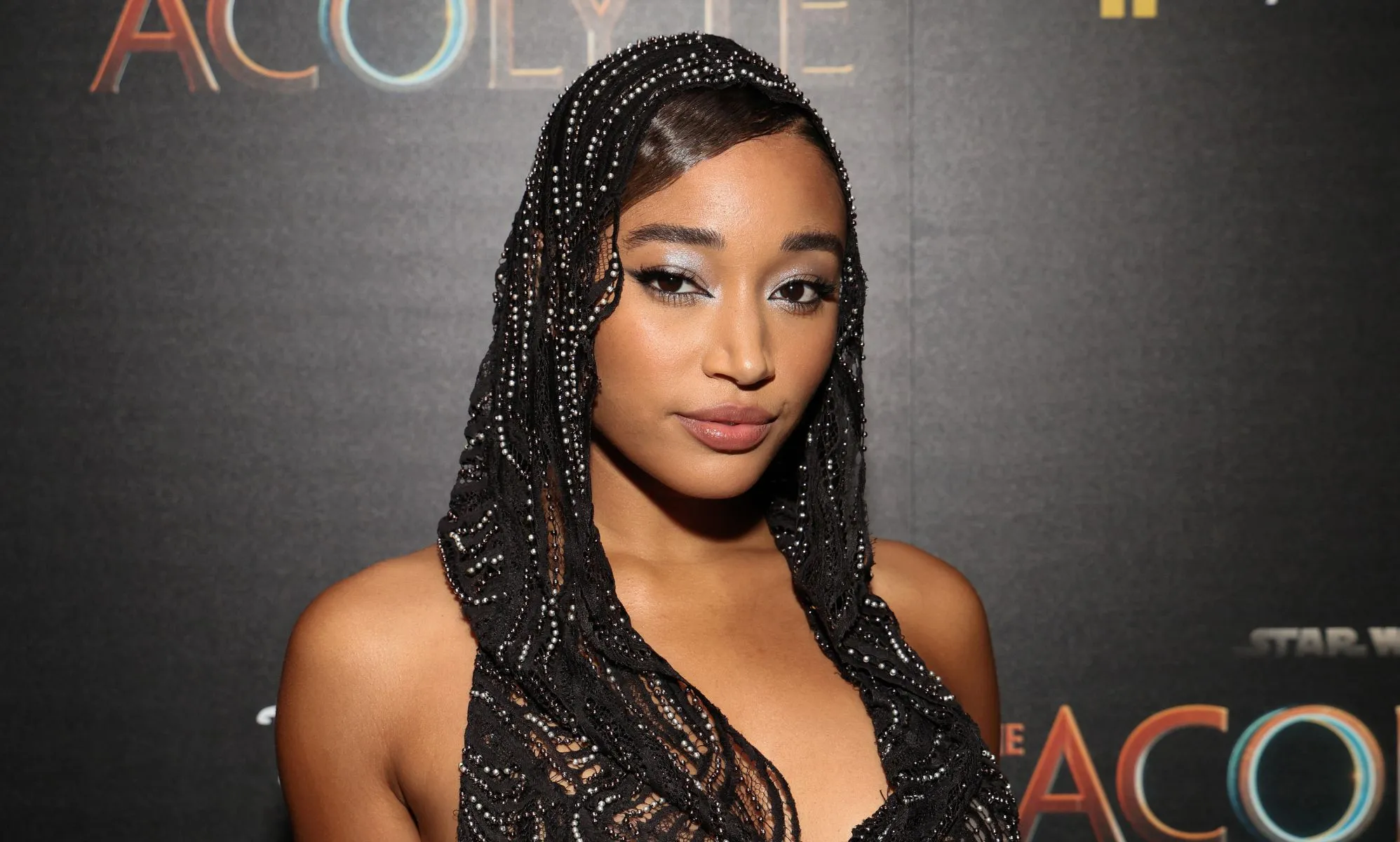 Amandla Stenberg wears a black lacy head covering while on the red carpet premiere of Star Wars: The Acolyte.
